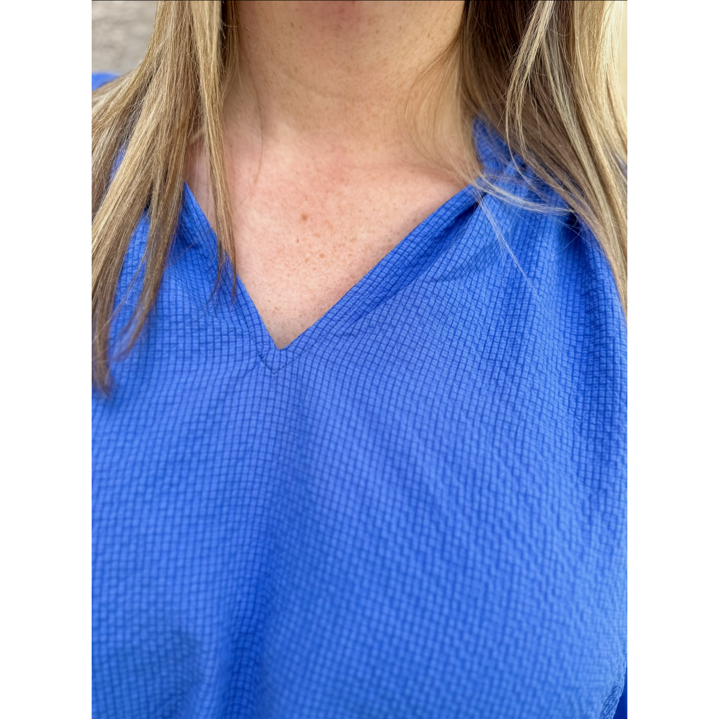 Close-up of a person wearing a blue shirt with visible skin texture.