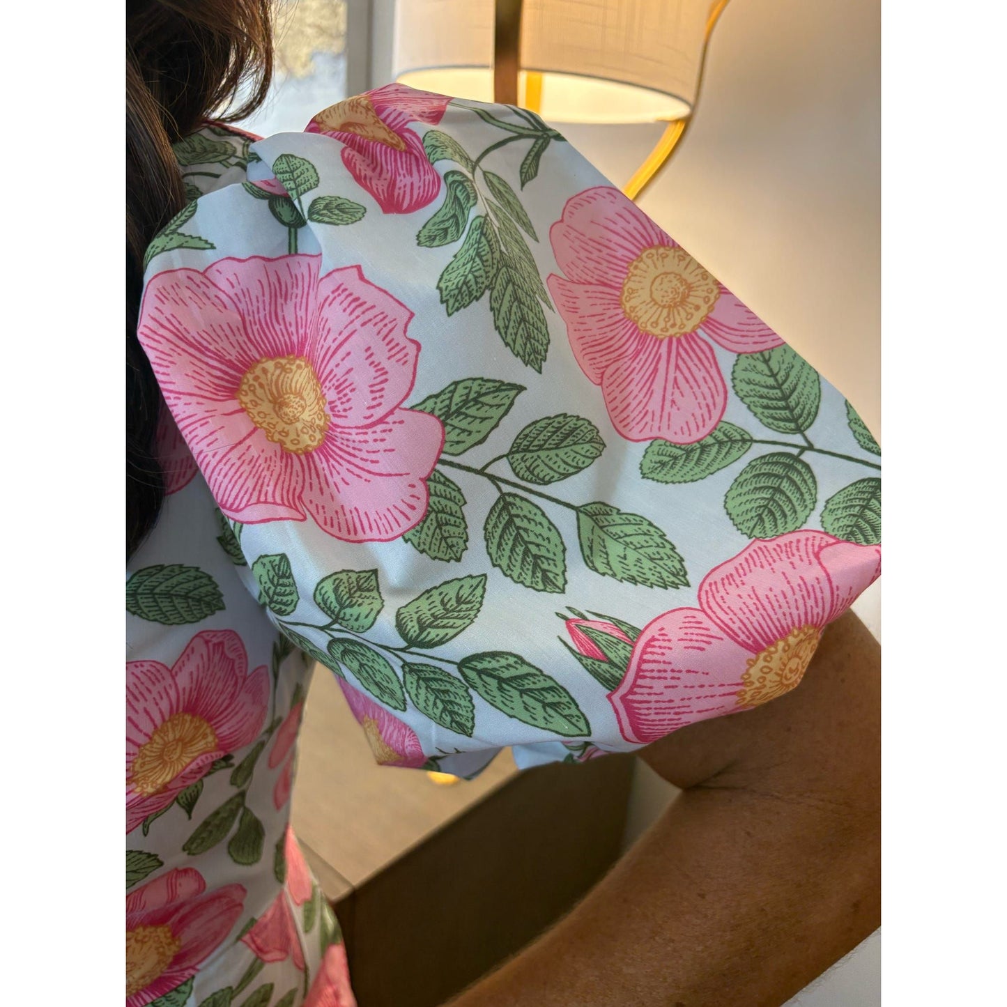 Floral-patterned fabric held by a person with a blurred background