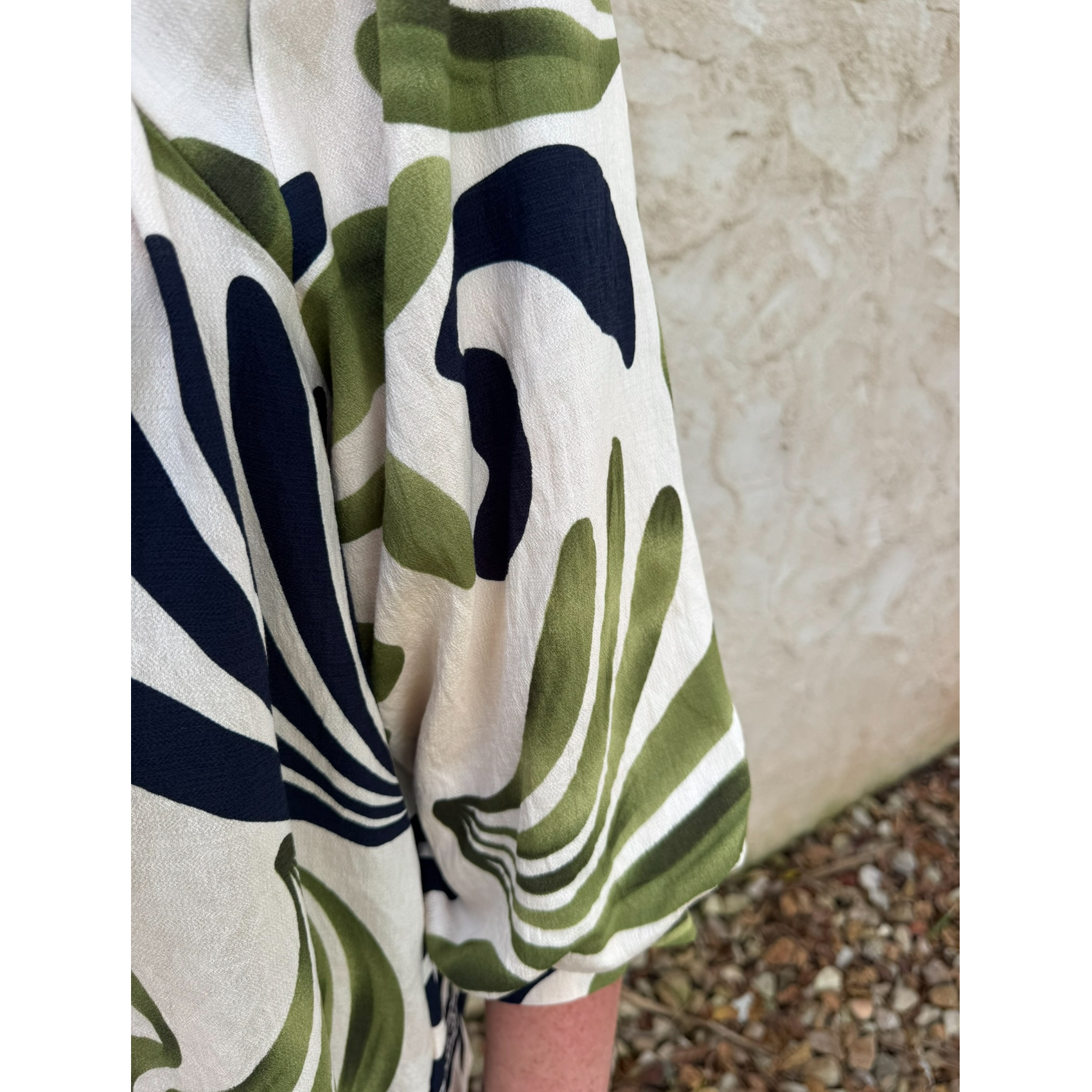 Patterned fabric with green, white, and black design on a neutral background