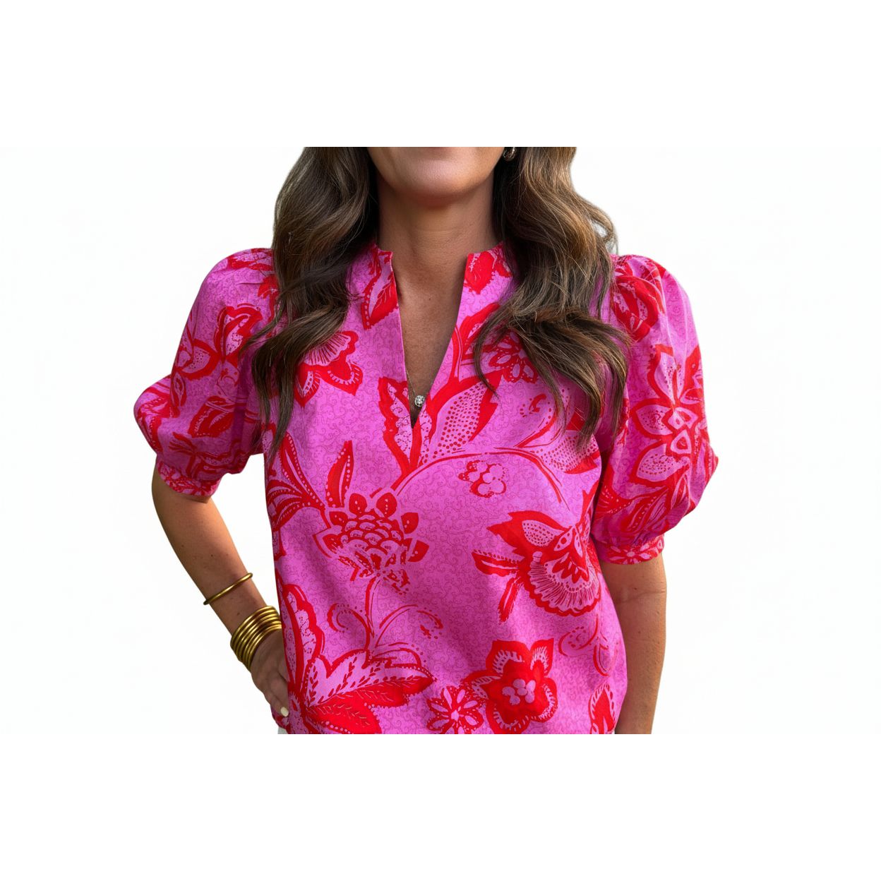 Person wearing a pink blouse with red floral patterns