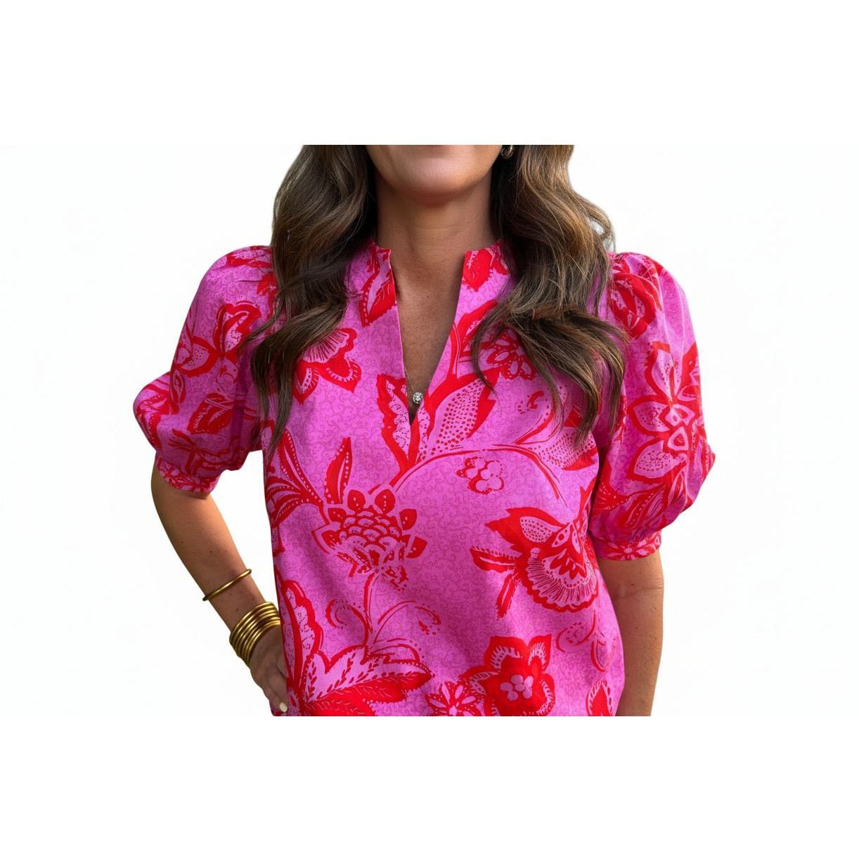Person wearing a pink blouse with red floral patterns
