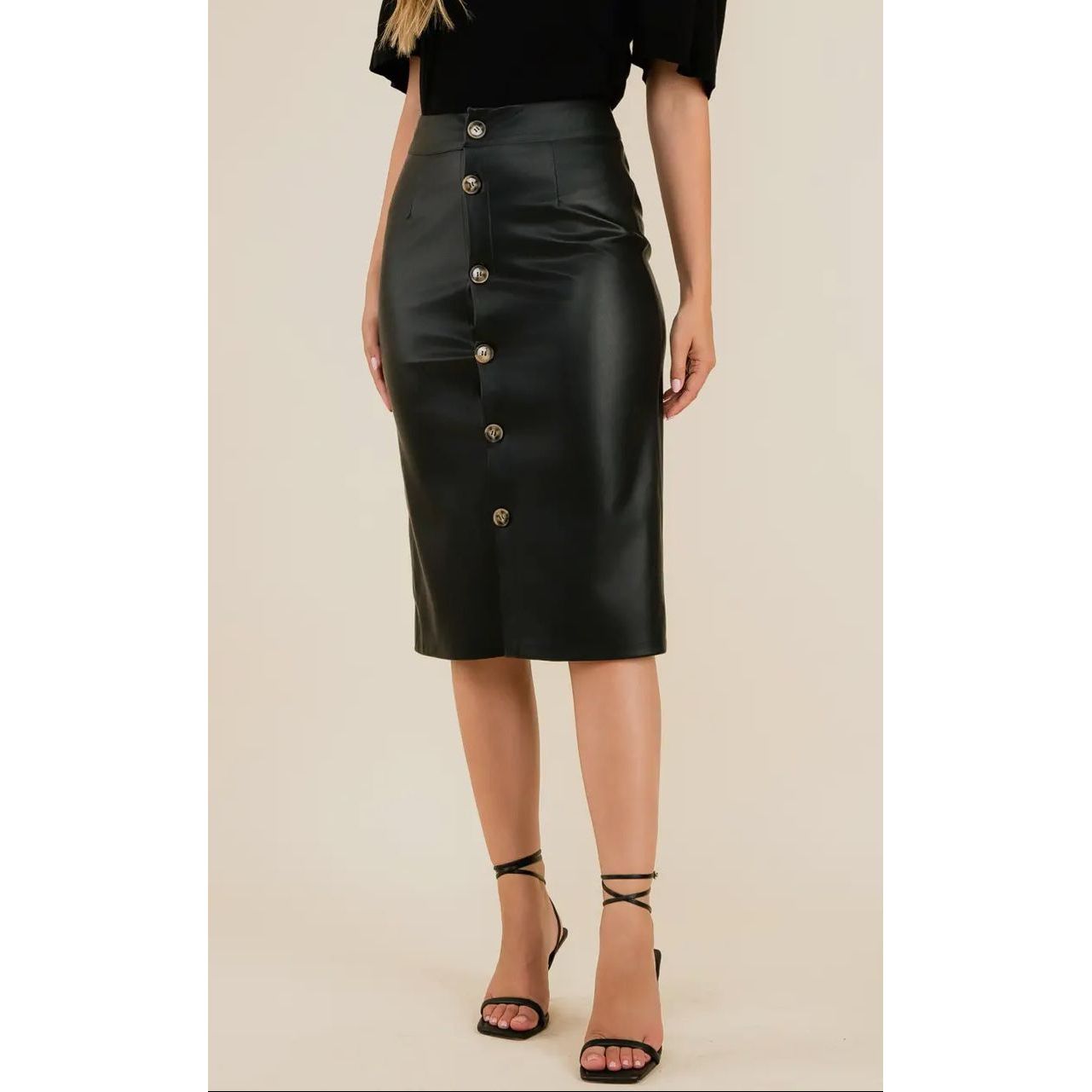 Black button-up skirt worn by a model on a beige background