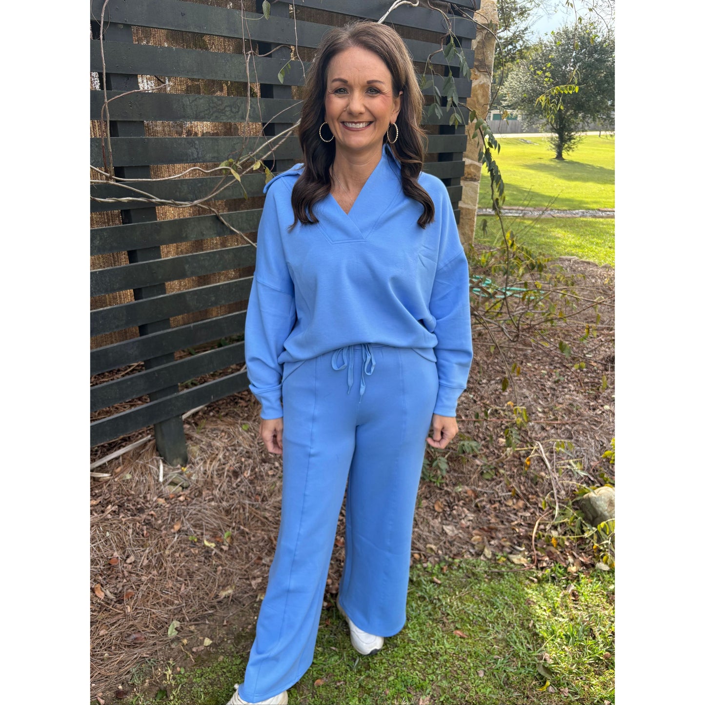 Woman in a blue outfit sitting on a bench outdoors