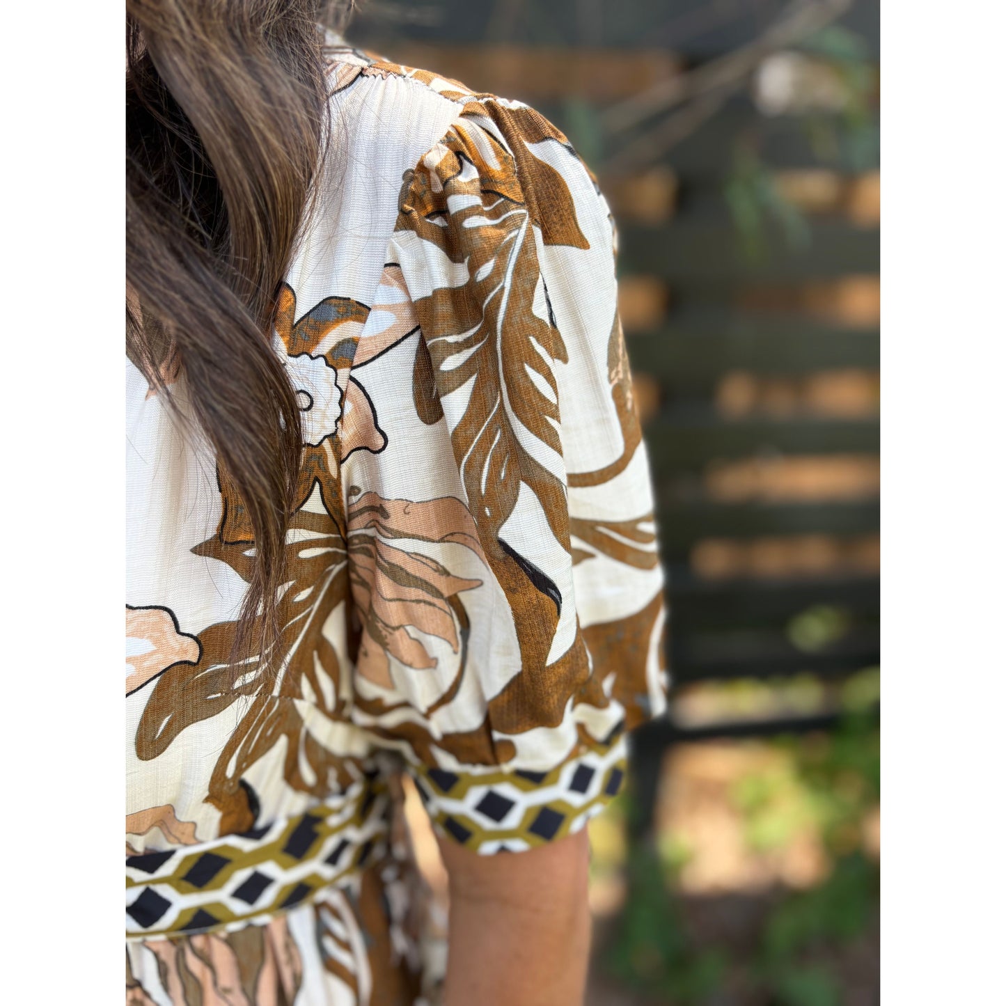 Person wearing a floral blouse with a blurred background