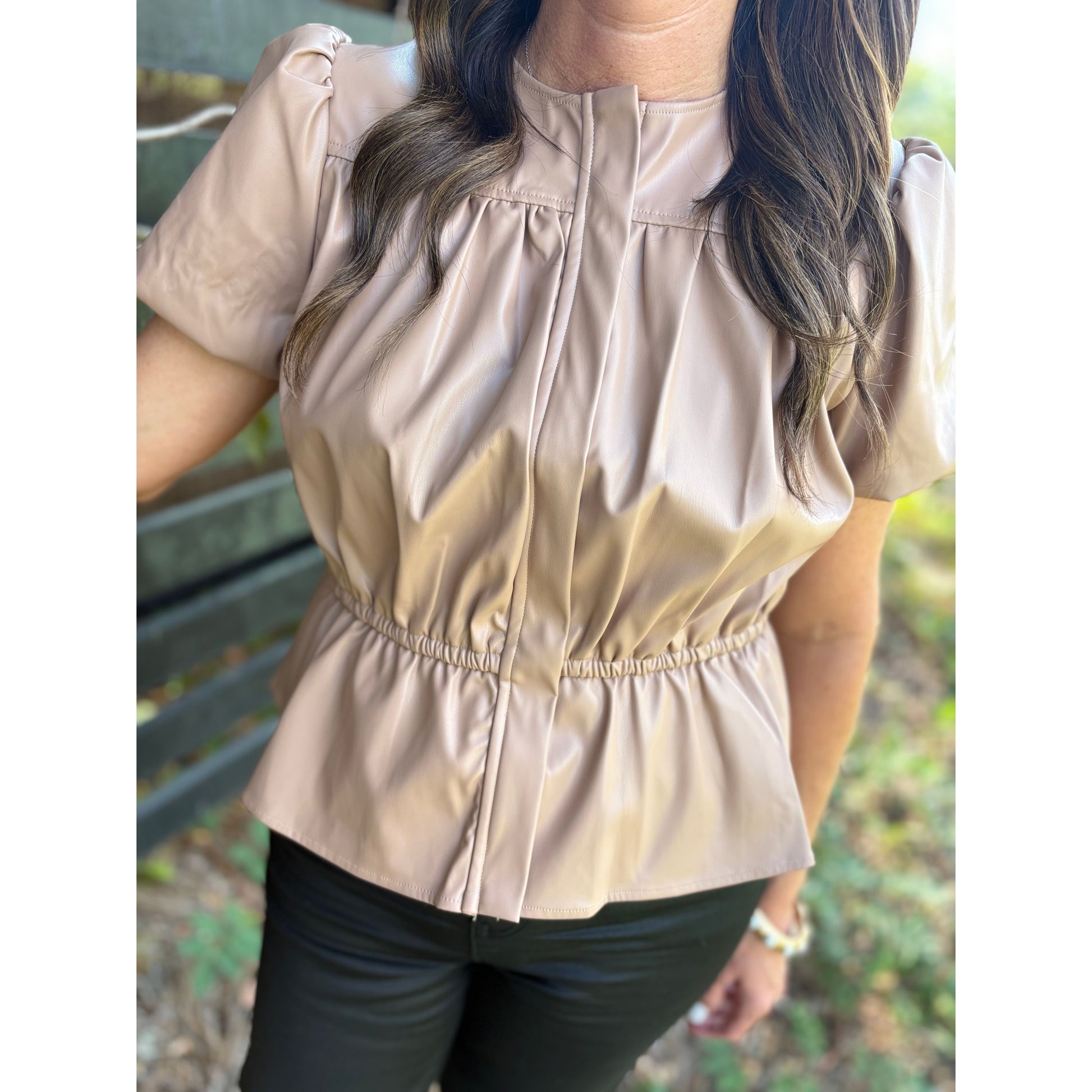 Beige blouse worn by a person with a blurred background