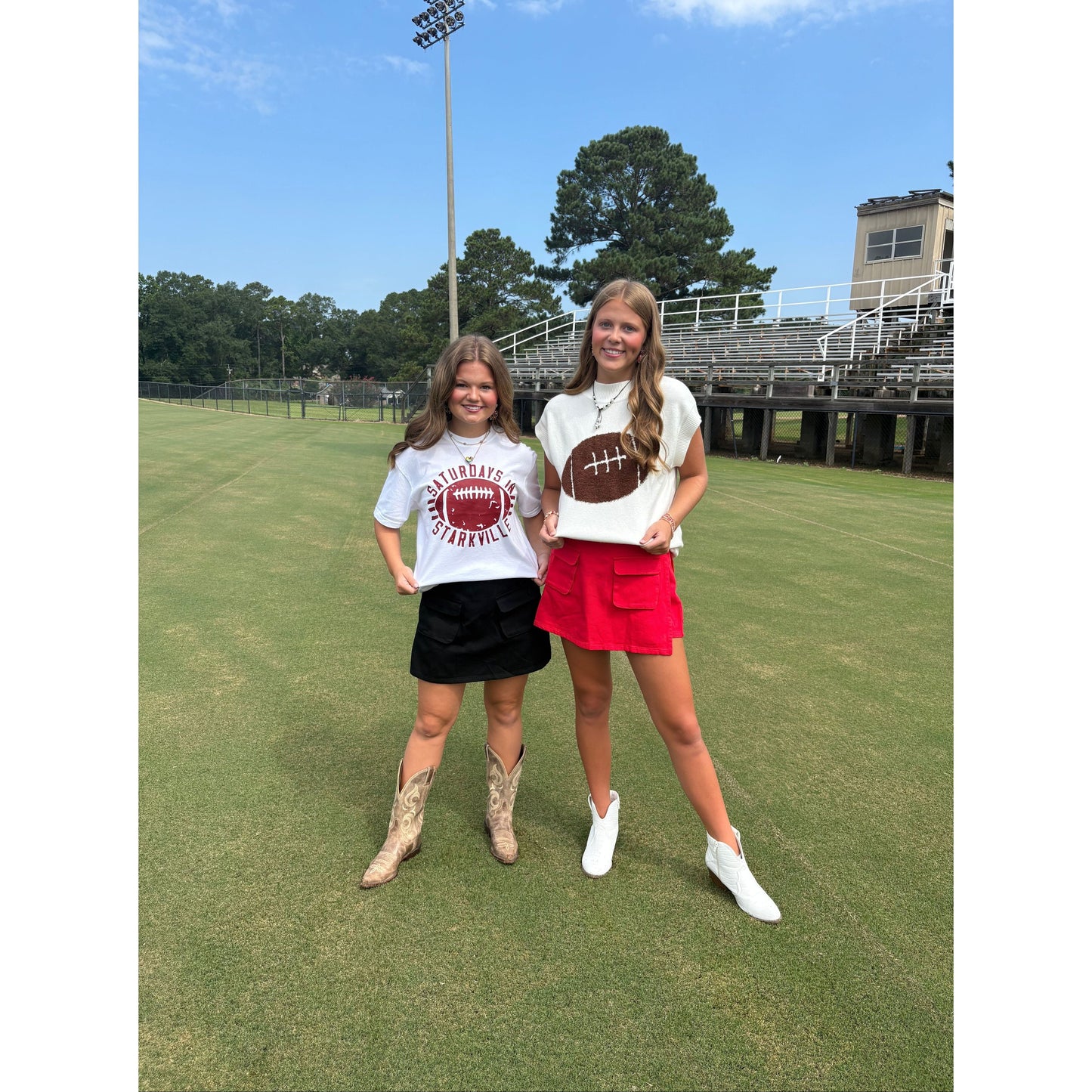 Two girls standing on a grassy field wearing white t-shirts with football designs.