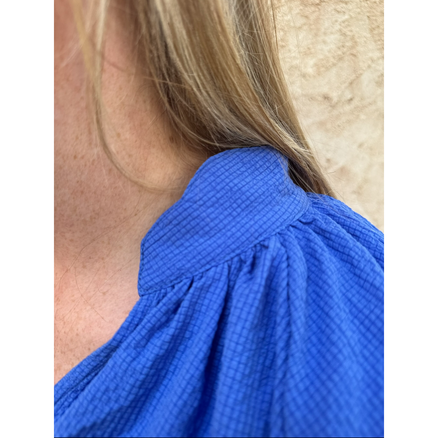 Close-up of a person wearing a blue garment with a textured pattern.