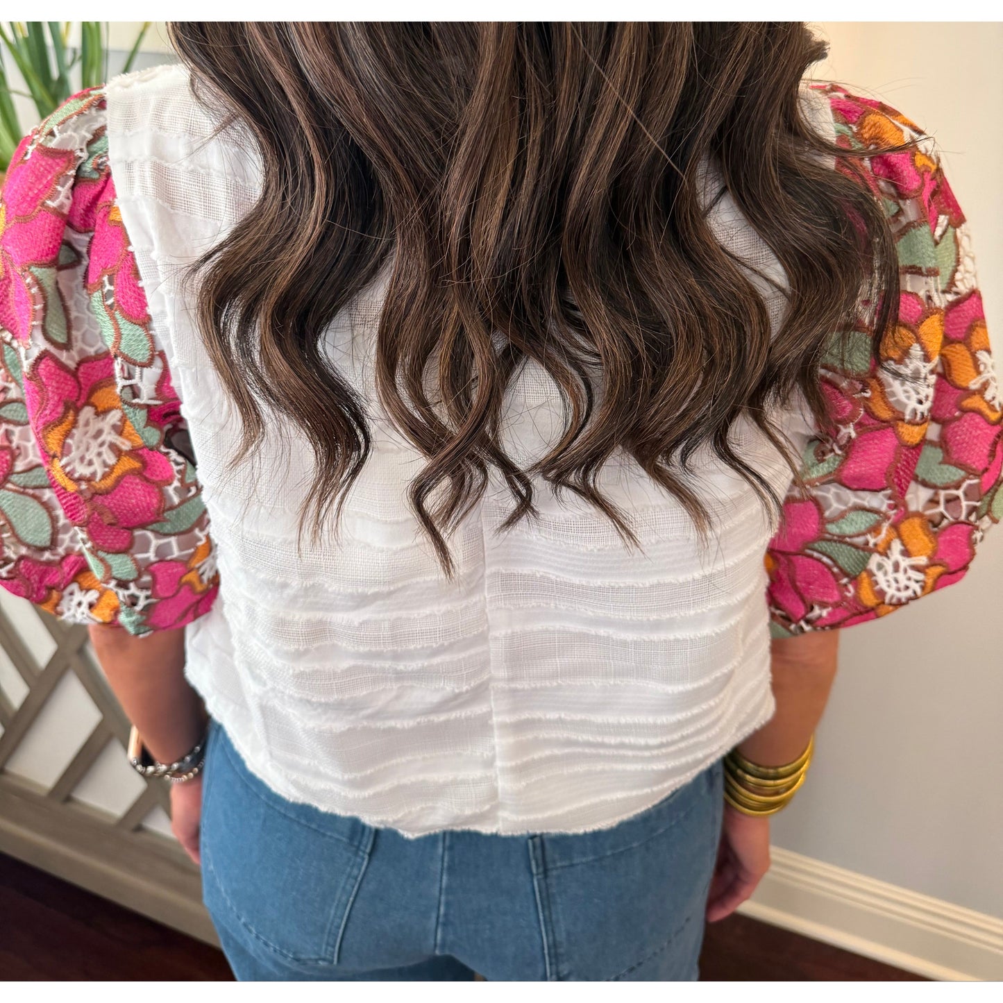 Person with long, wavy hair wearing a floral headband indoors.