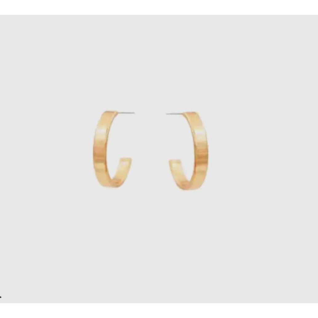 Gold hoop earrings on a light gray background