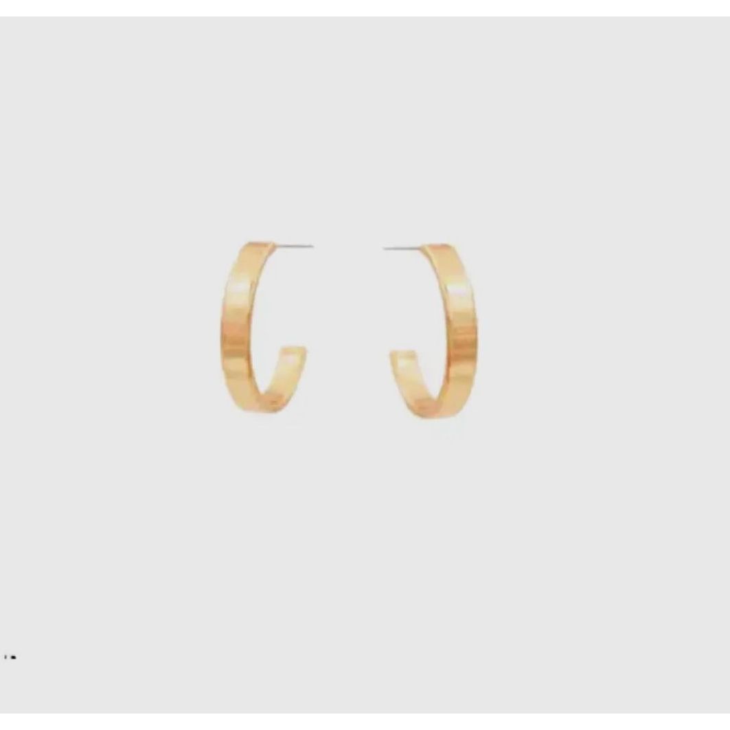 Gold hoop earrings on a light gray background