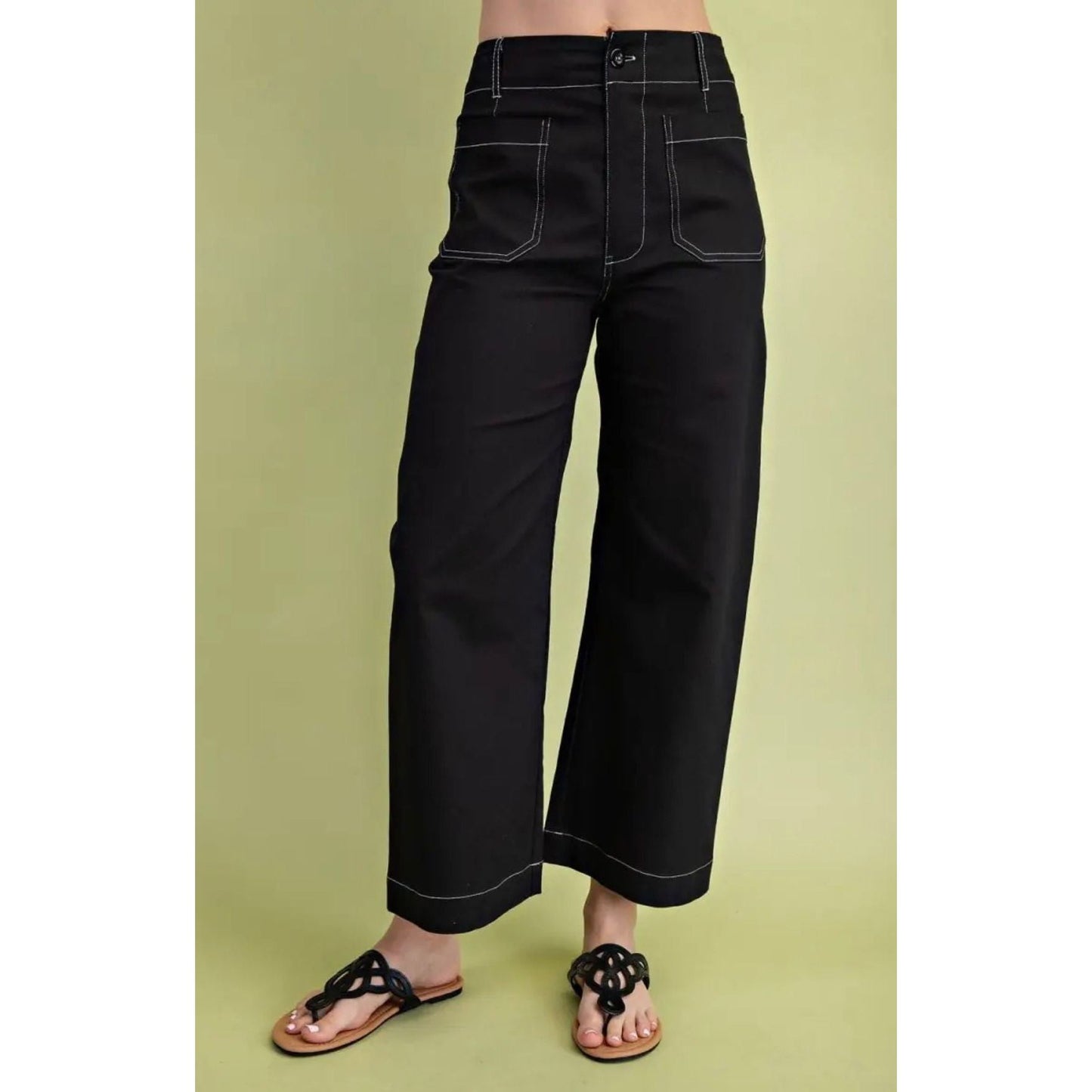 Black wide-leg pants worn by a person on a green background