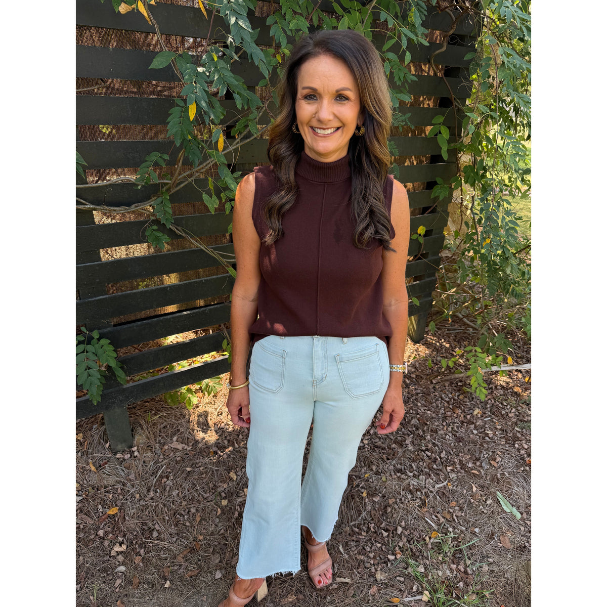 Annie Ks Boutique model wearing Blizzard Blue high-rise wide-leg cropped jeans with a raw hem and brown sleeveless top