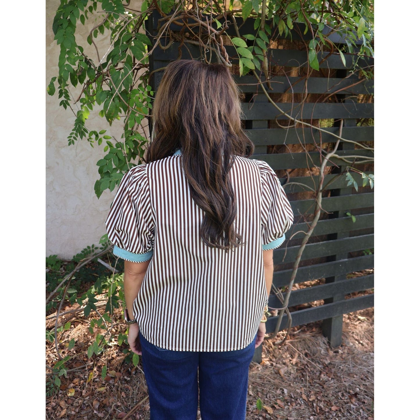 Back view of a woman wearing an Annie Ks Boutique brown and cream striped cotton top with short puff sleeves.