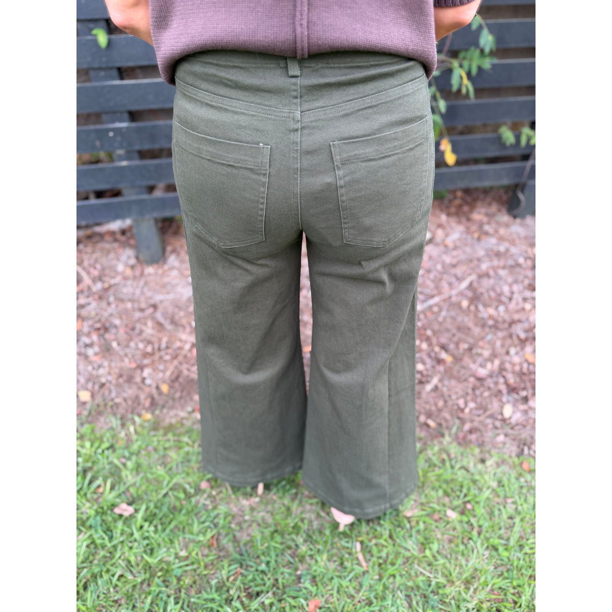 Annie Ks Boutique olive wide-leg trousers featuring functional back pockets and a relaxed fit from a rear view