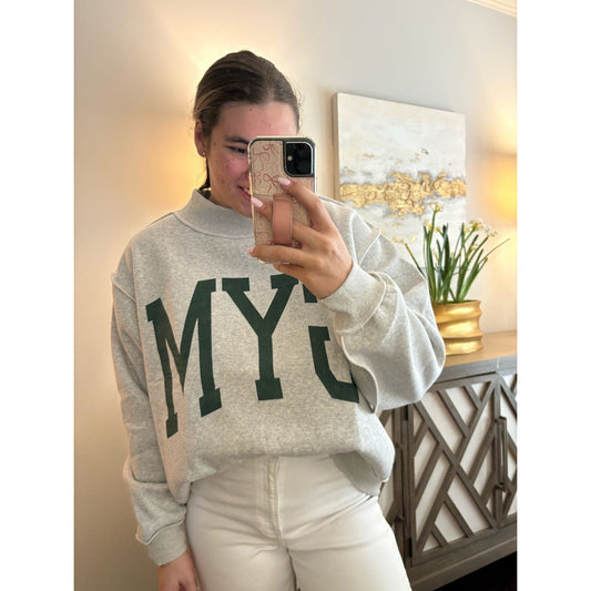 Person wearing a gray sweatshirt with 'MY' printed on it, taking a mirror selfie.