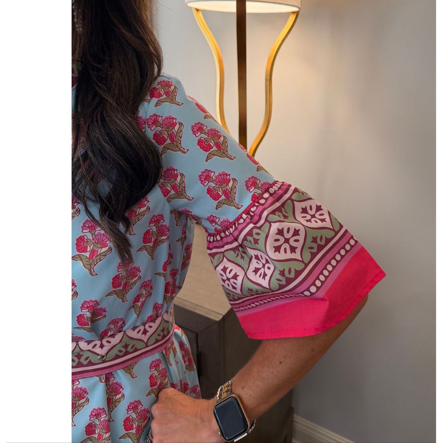 Woman wearing a patterned dress with a lamp in the background