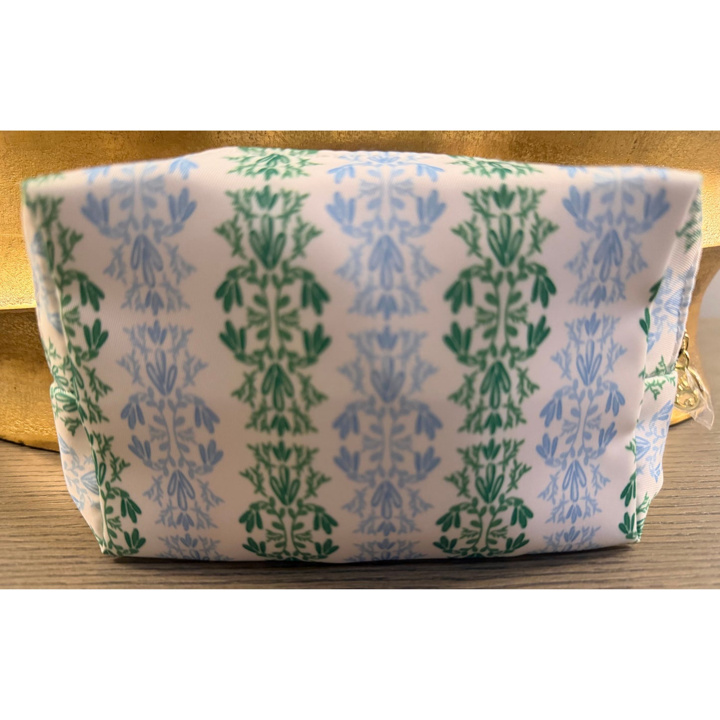 Small cosmetic bag sitting on wood surface. 