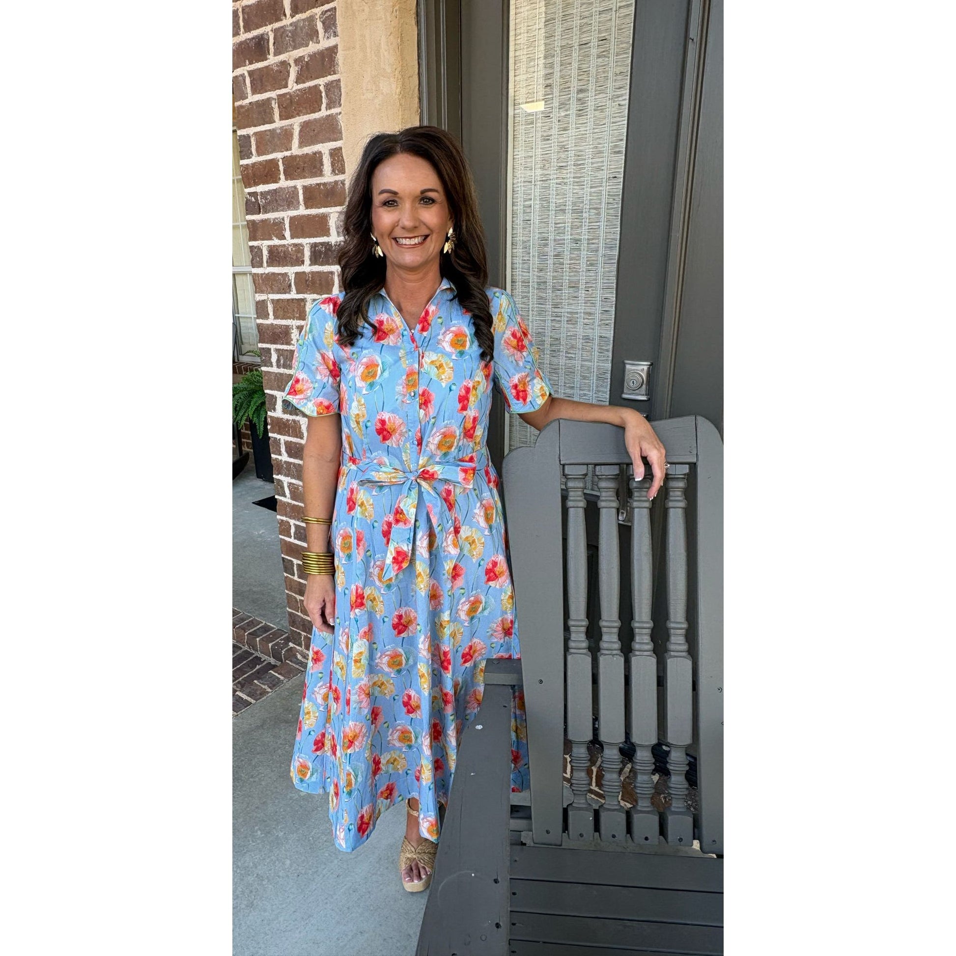 Woman in a floral dress standing on a porch