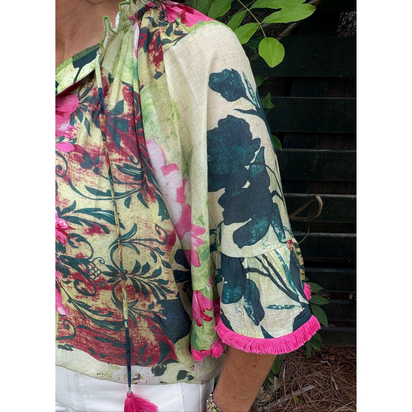 Rolled-up floral fabric with pink trim on a surface outdoors.