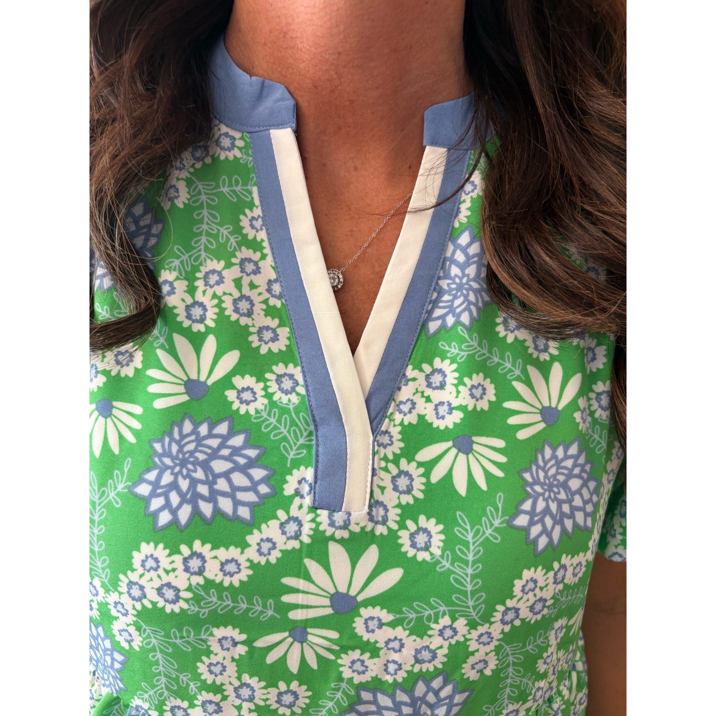 Green floral dress with blue and white accents worn by a person