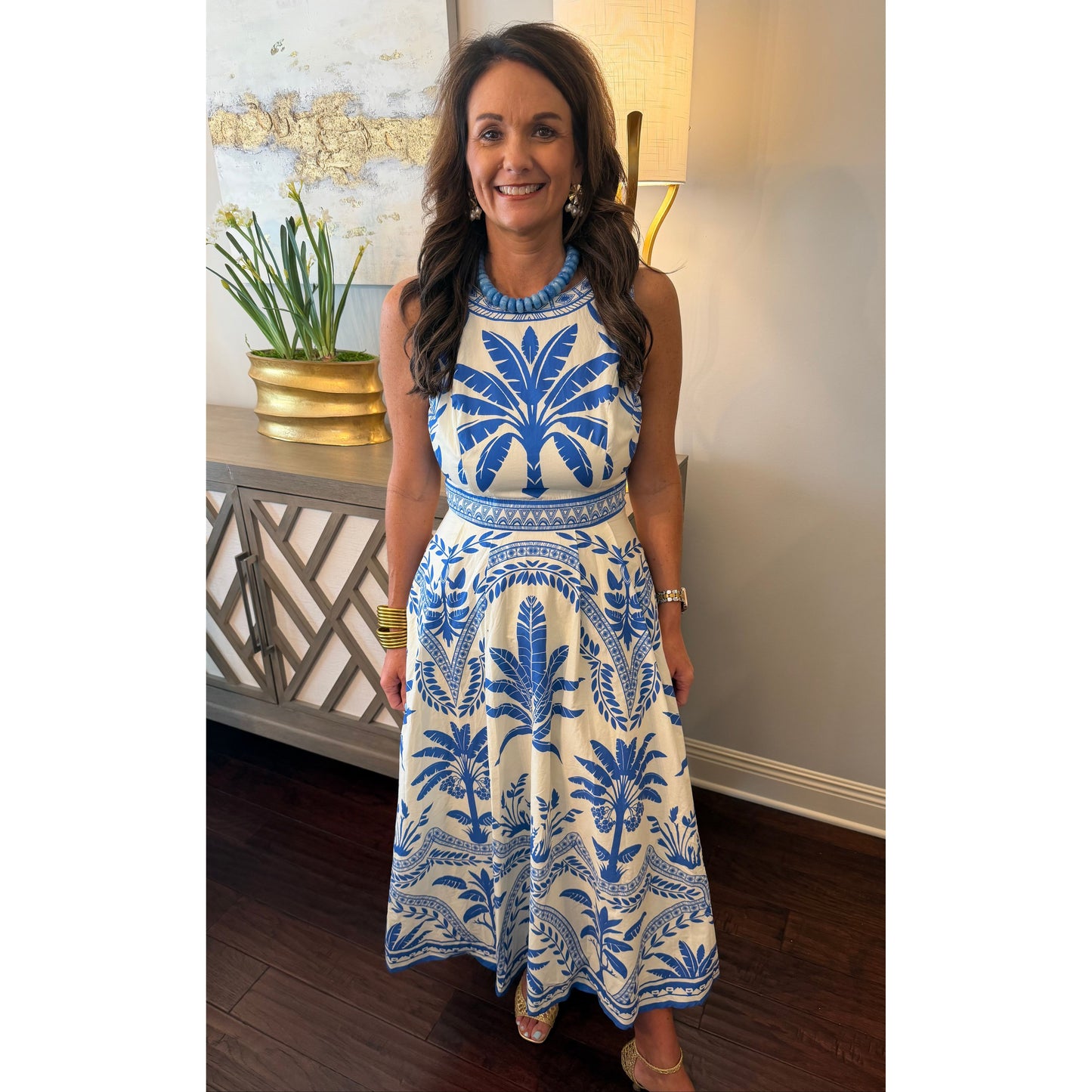 Woman wearing a blue and white patterned dress in an indoor setting.