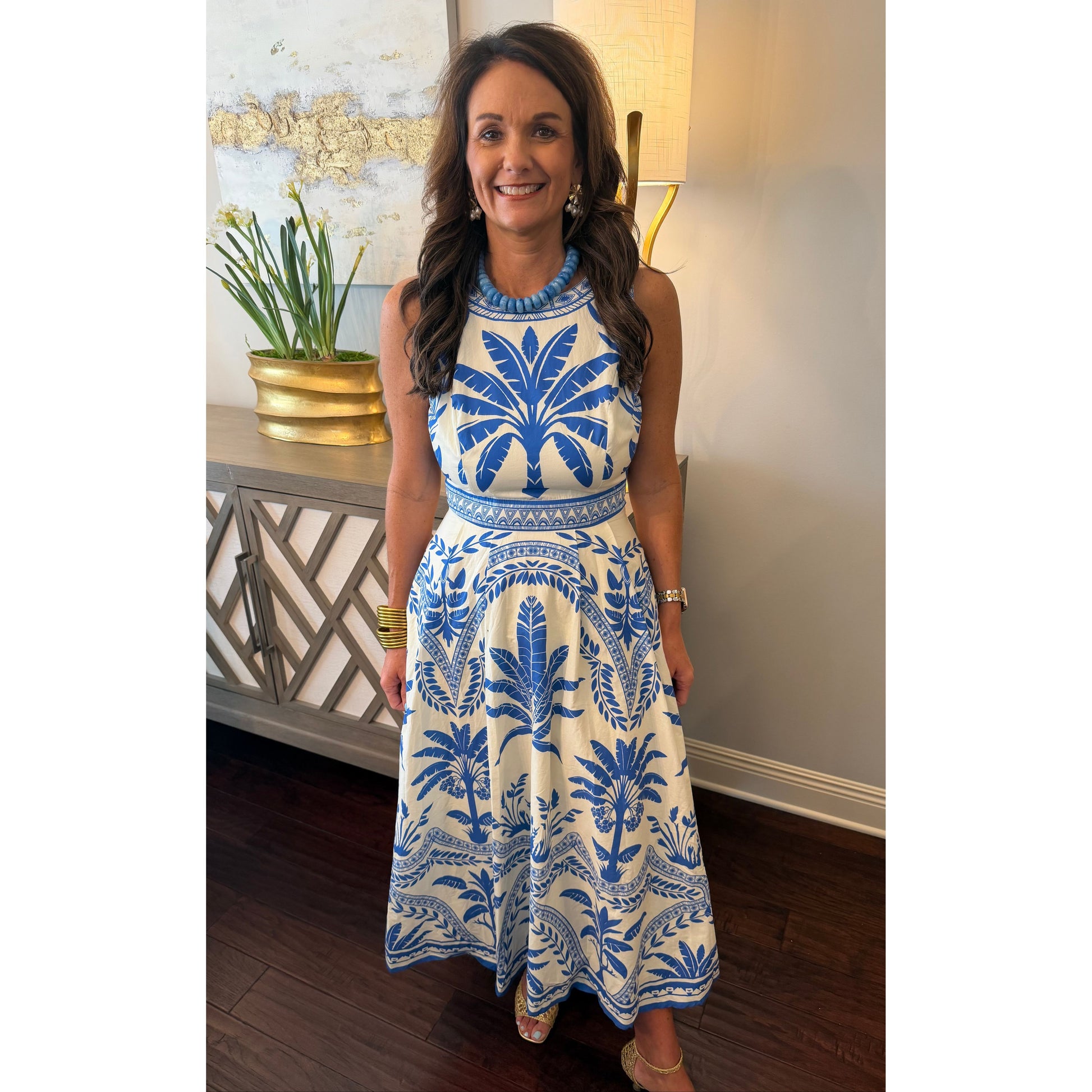 Woman wearing a blue and white patterned dress in an indoor setting.