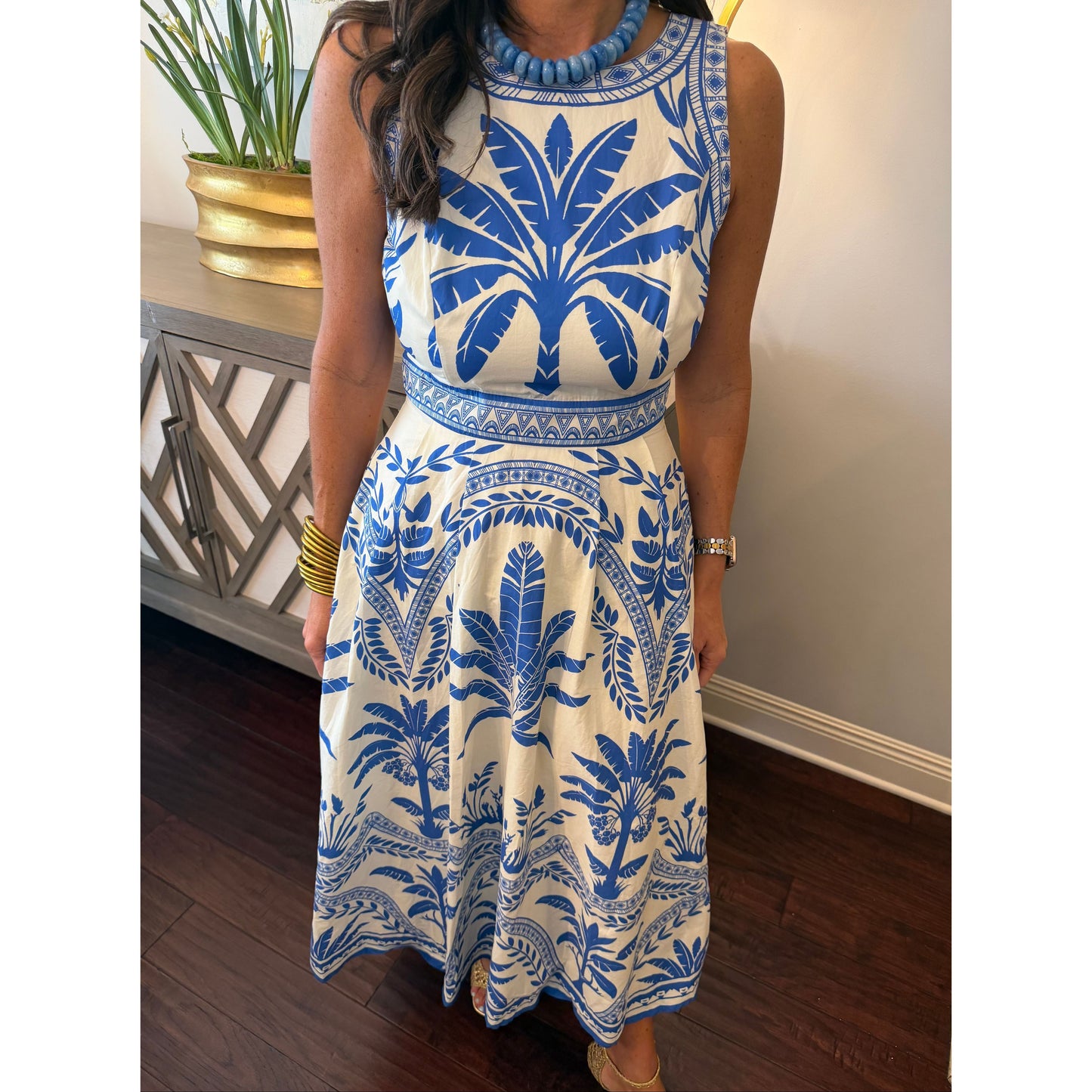 Woman wearing a blue and white patterned dress indoors.