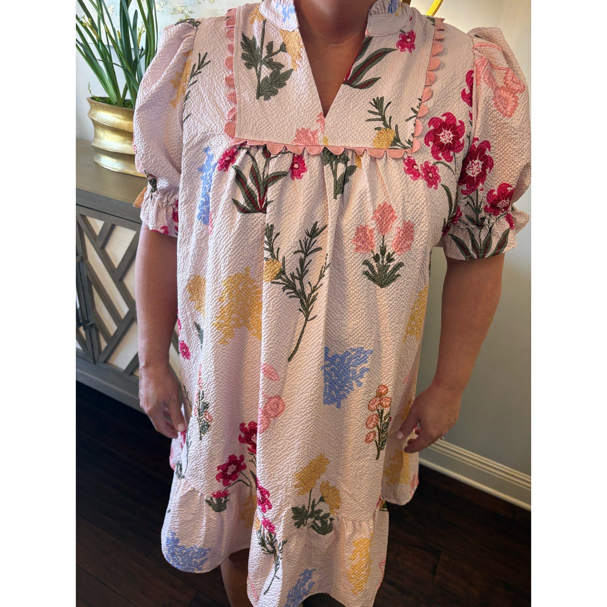 Floral dress with colorful patterns worn by a person indoors.