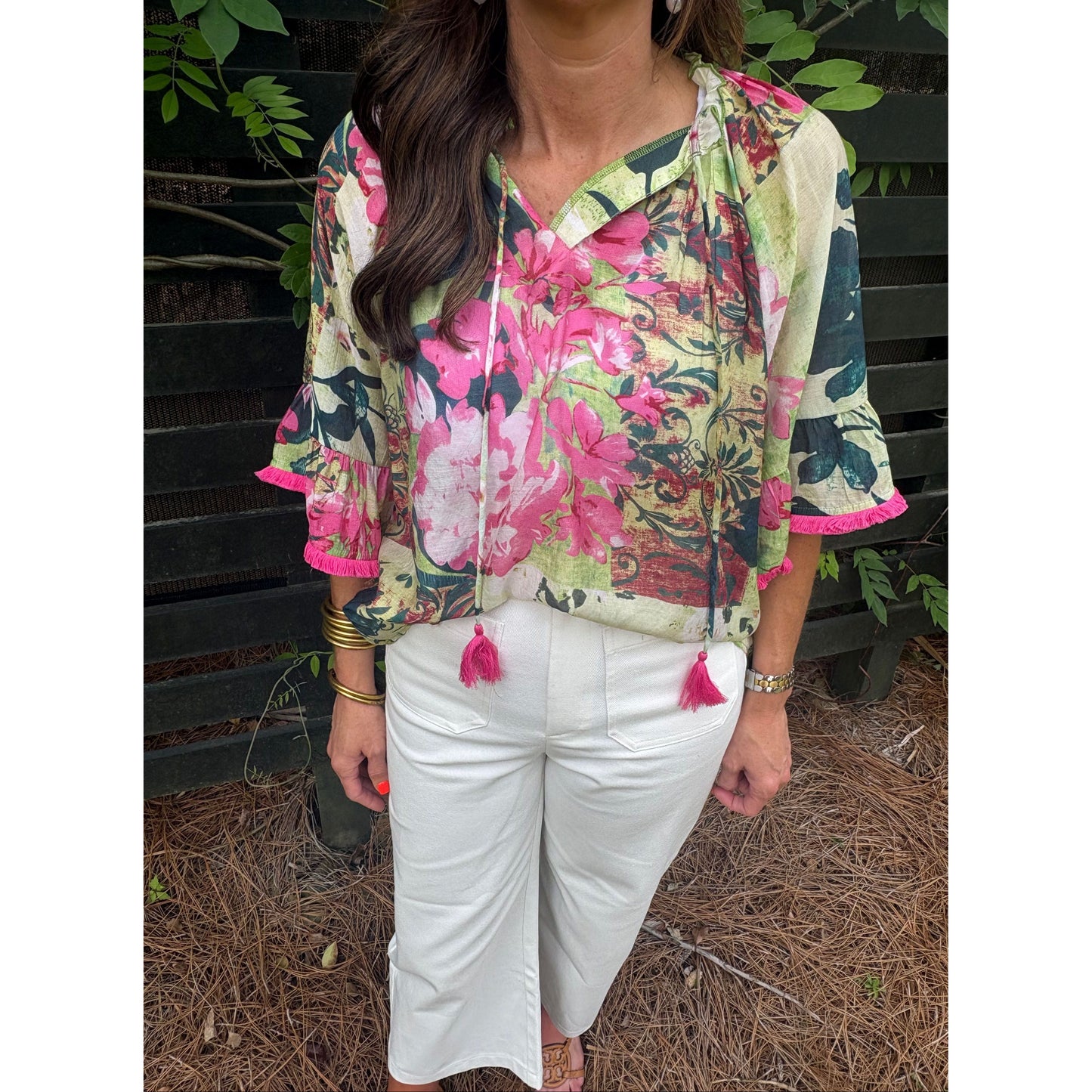 Person wearing a floral jacket and white pants in an outdoor setting