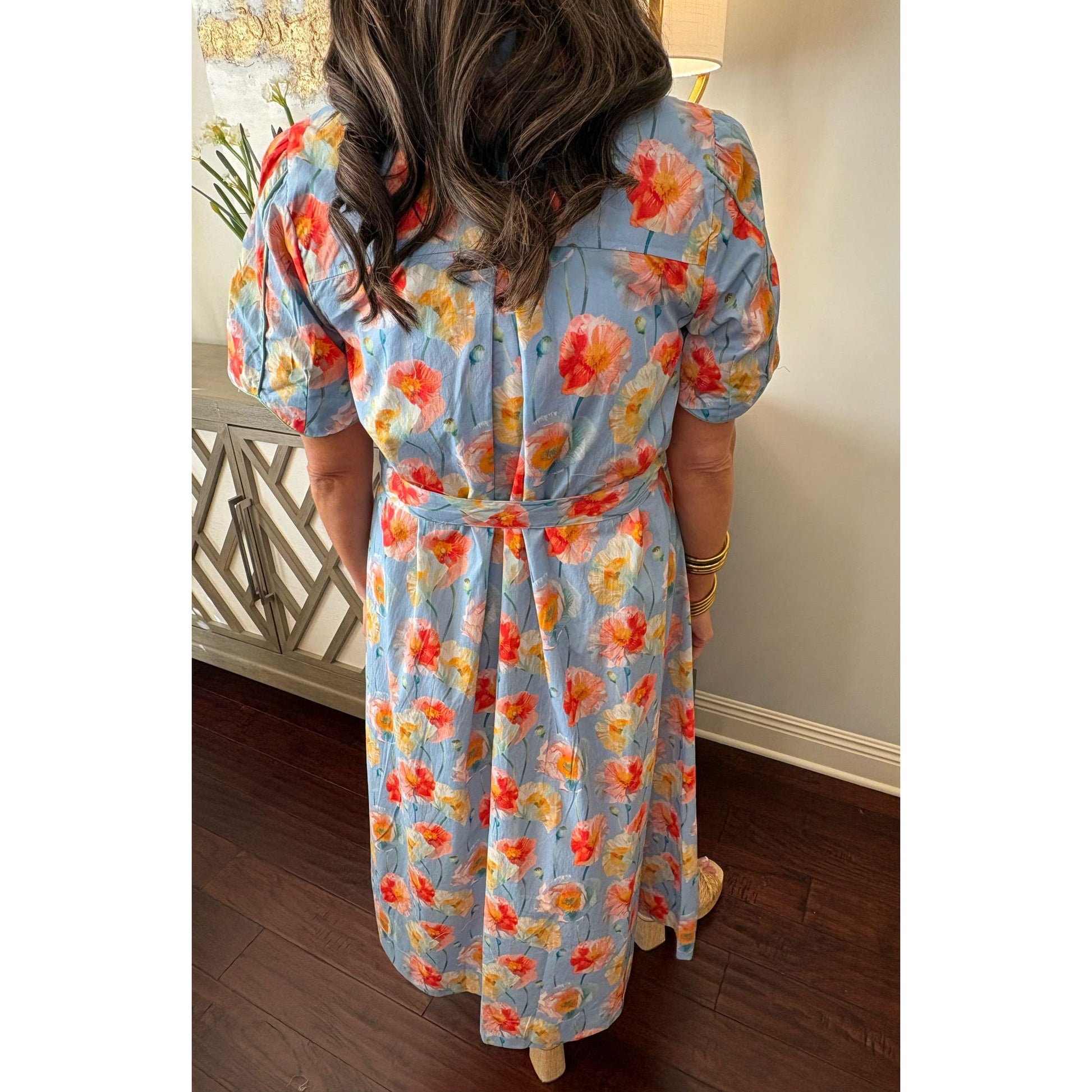 Person wearing a floral dress with a neutral background