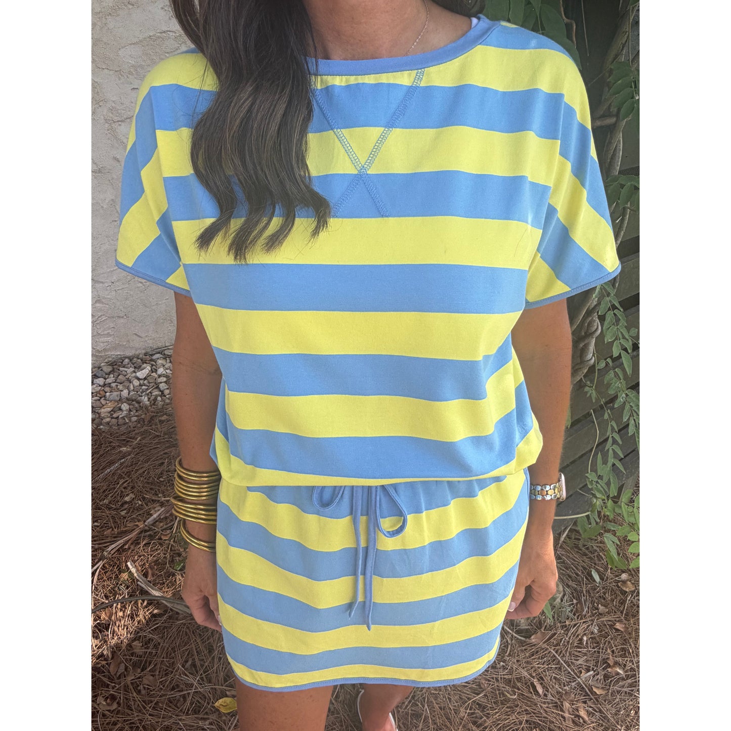 Person wearing a yellow and blue striped dress outdoors.