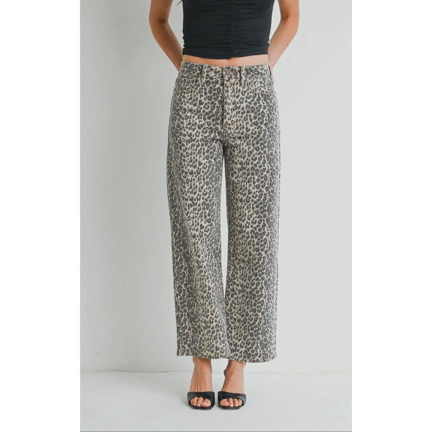 Person wearing leopard print pants on a plain background