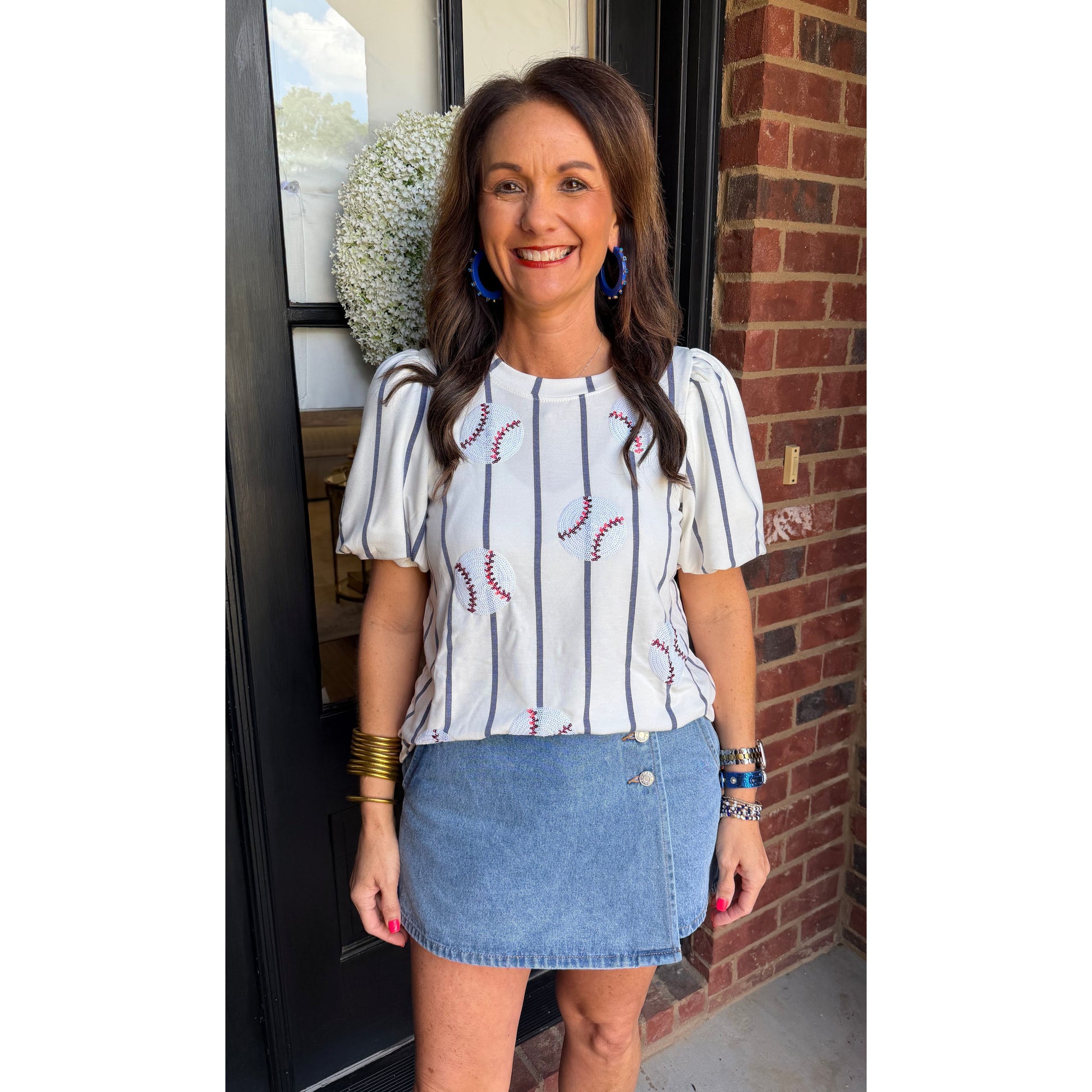 Woman standing in front of a door with a brick wall background
