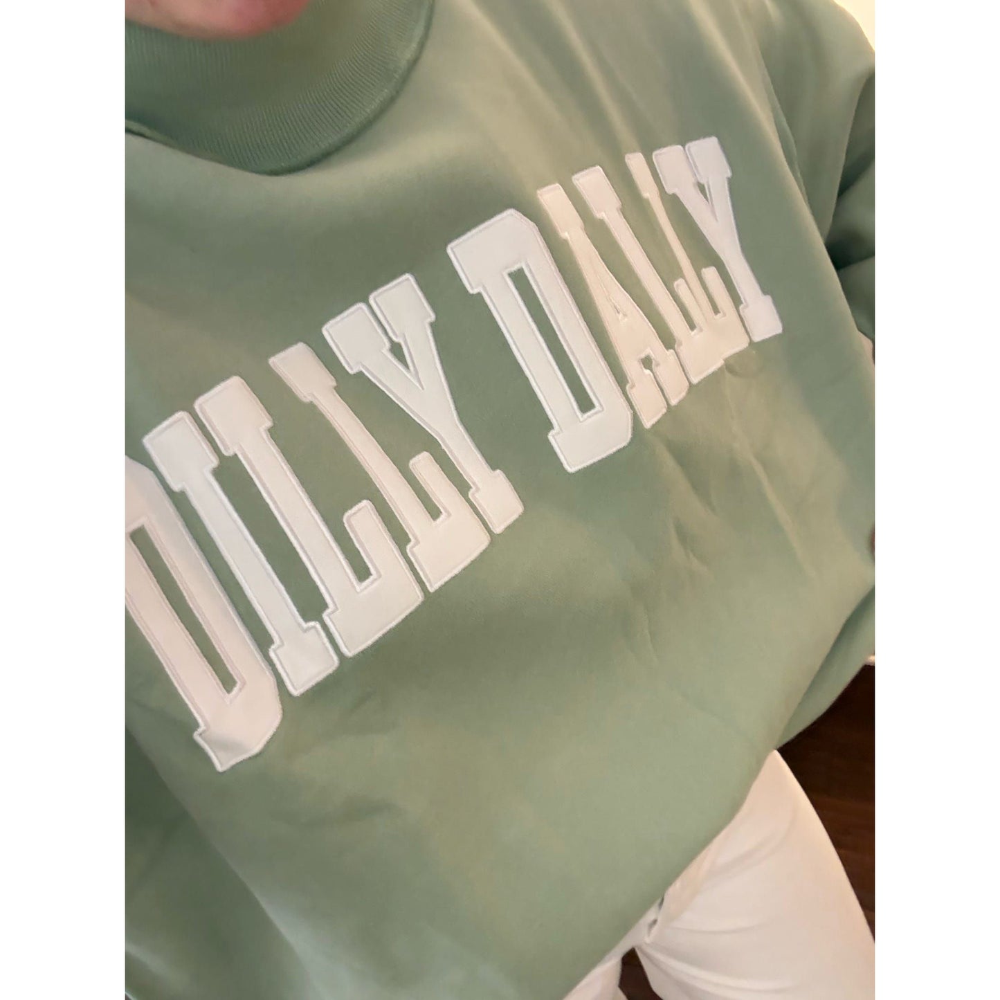Green sweatshirt with 'DILLY DALLY' text in white
