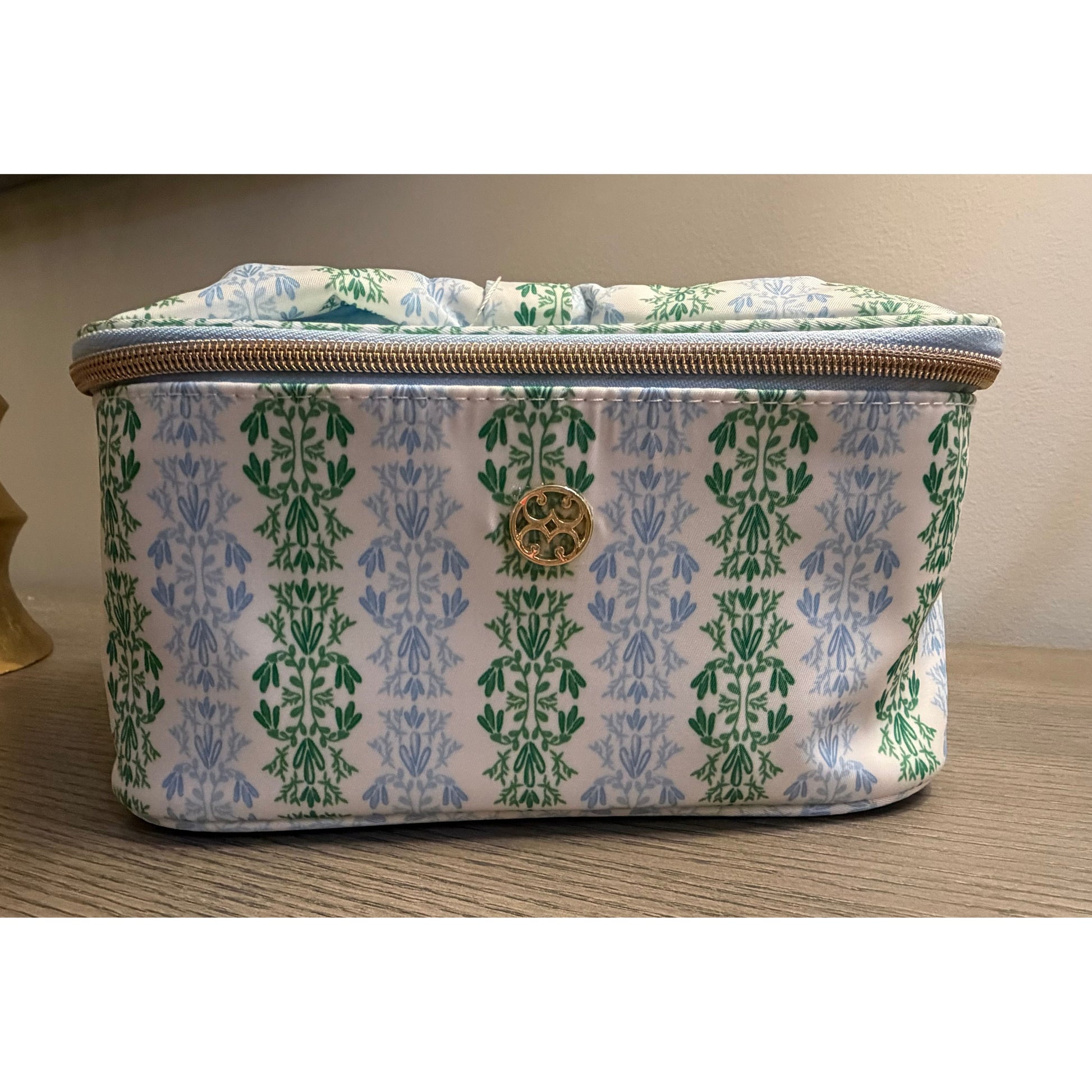 Rectangular fabric pouch with green and blue pattern on a wooden surface