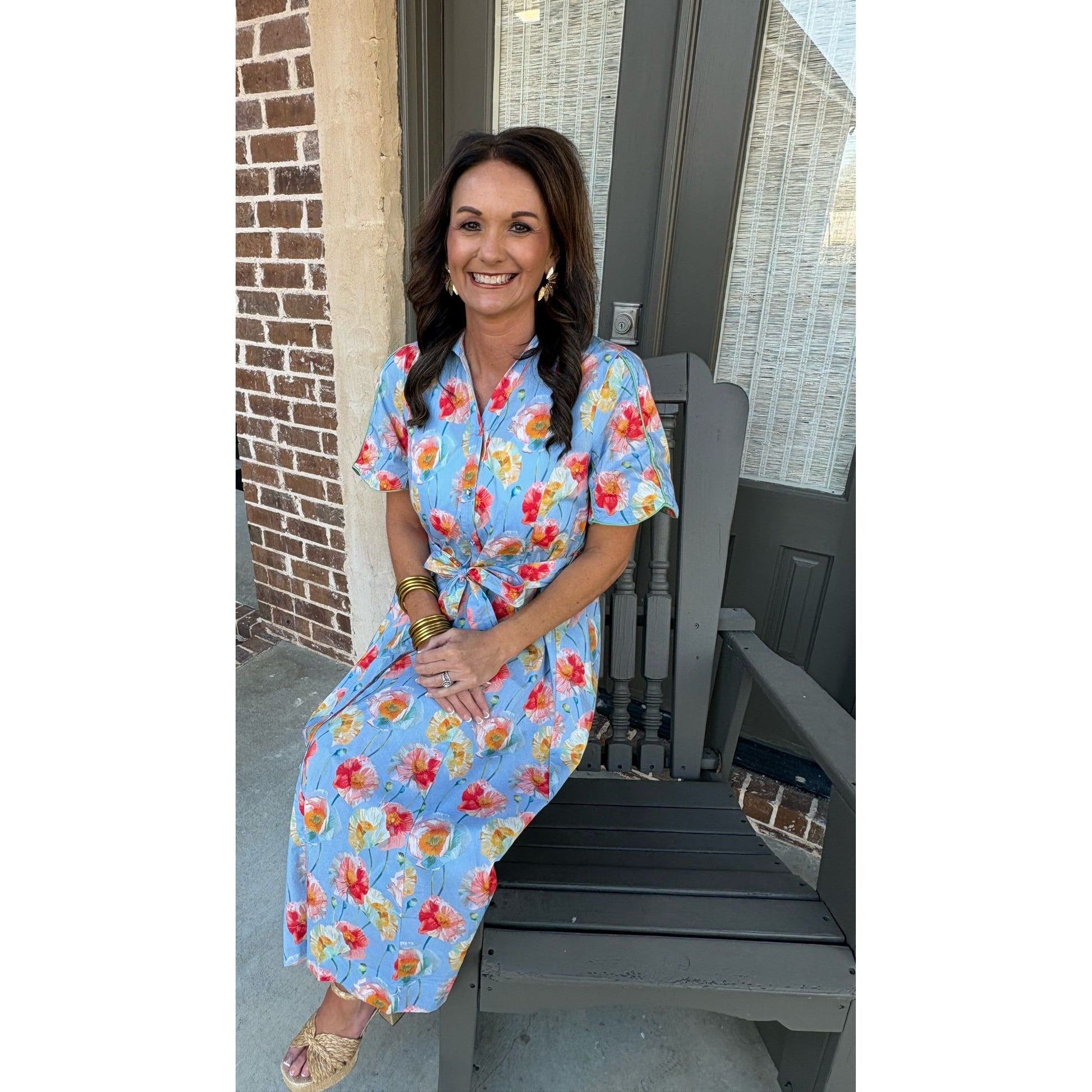 Woman in a floral dress standing on a porch