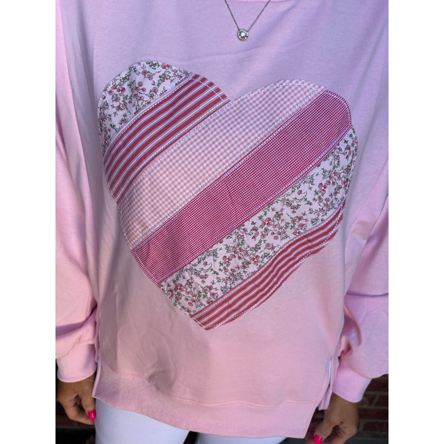 Pink sweatshirt with a heart design made of different patterns