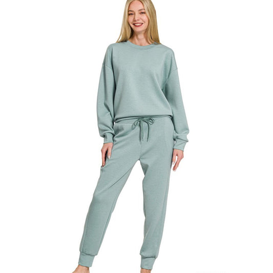 Woman wearing a light green lounge set on a white background