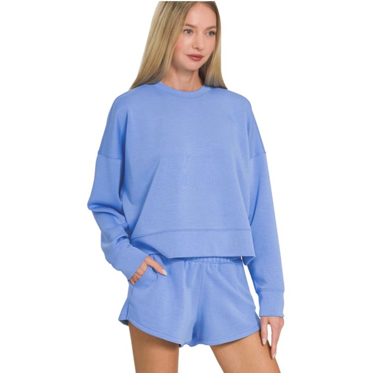 Woman wearing a light blue sweatshirt and shorts set on a white background