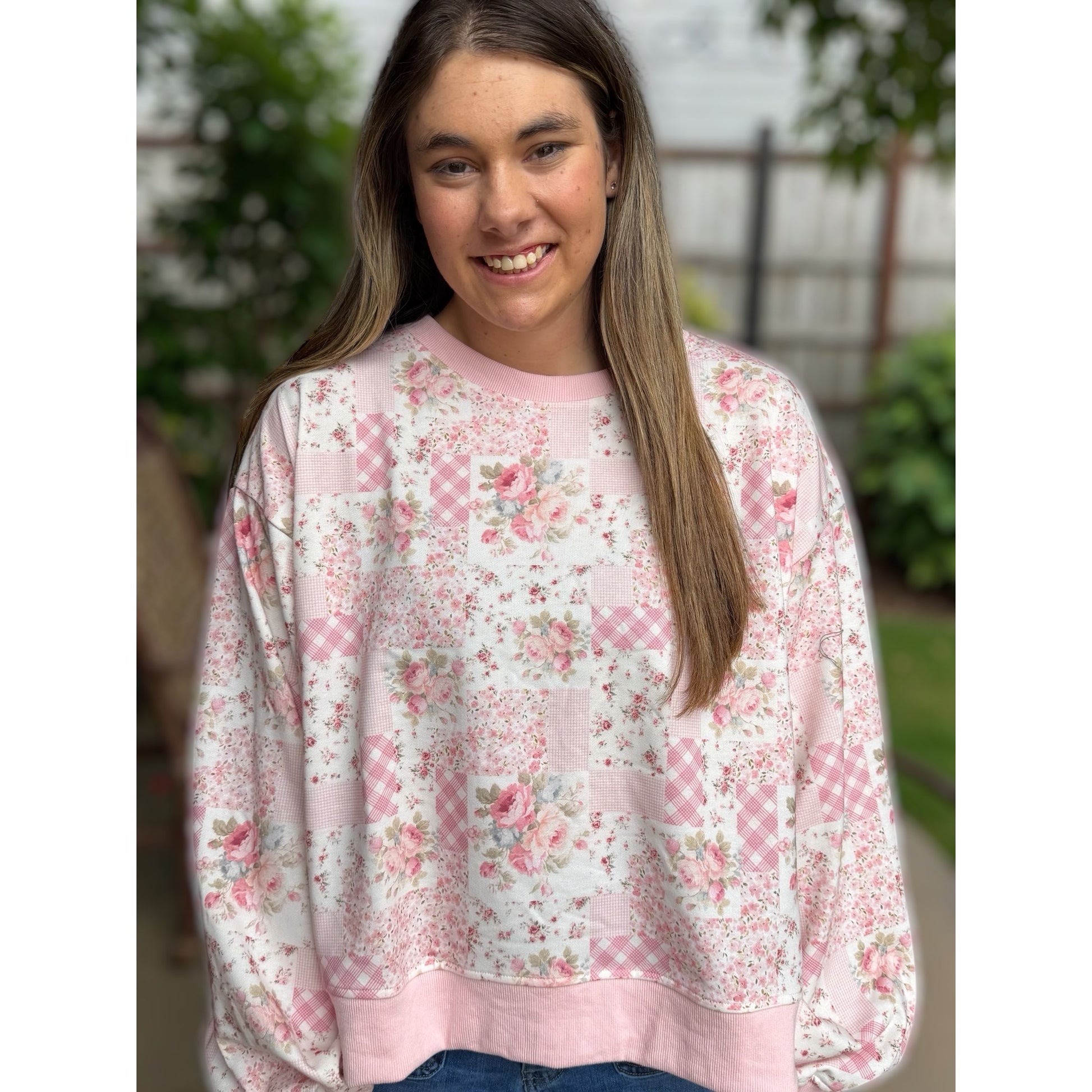 Person wearing a pink floral sweatshirt outdoors