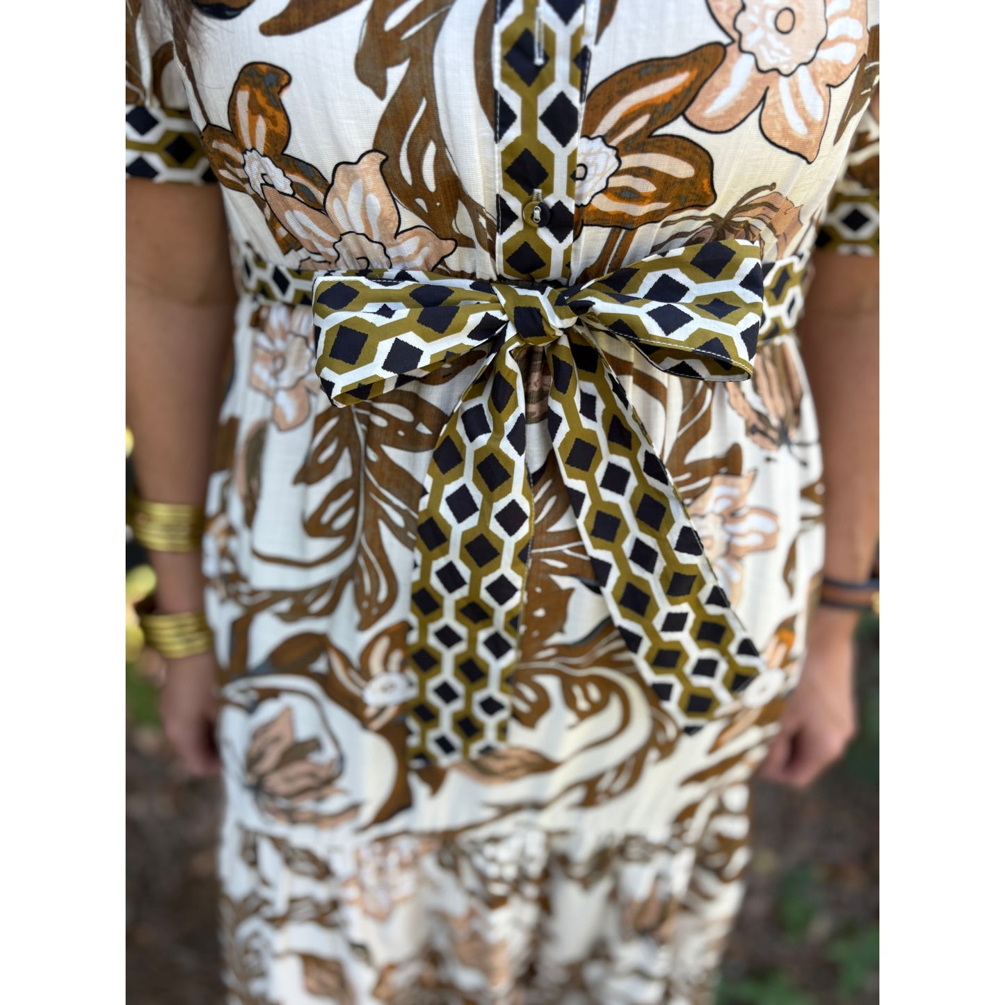 Close-up of a patterned dress with a bow detail.