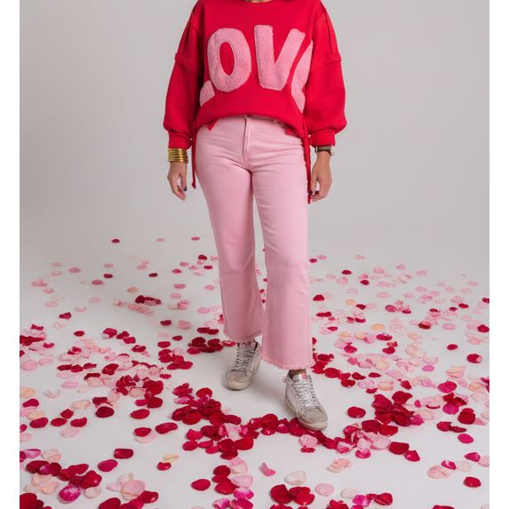 Person wearing a red sweatshirt with pink 'LOVE' letters and pink pants.