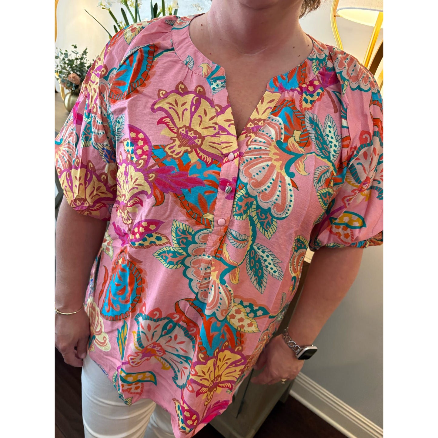 Person wearing a colorful patterned shirt with a blurred background