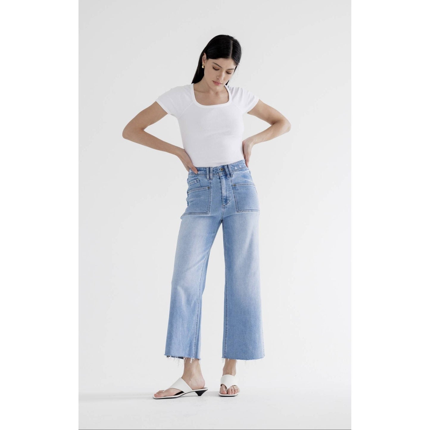Woman wearing a white t-shirt and light blue jeans on a white background