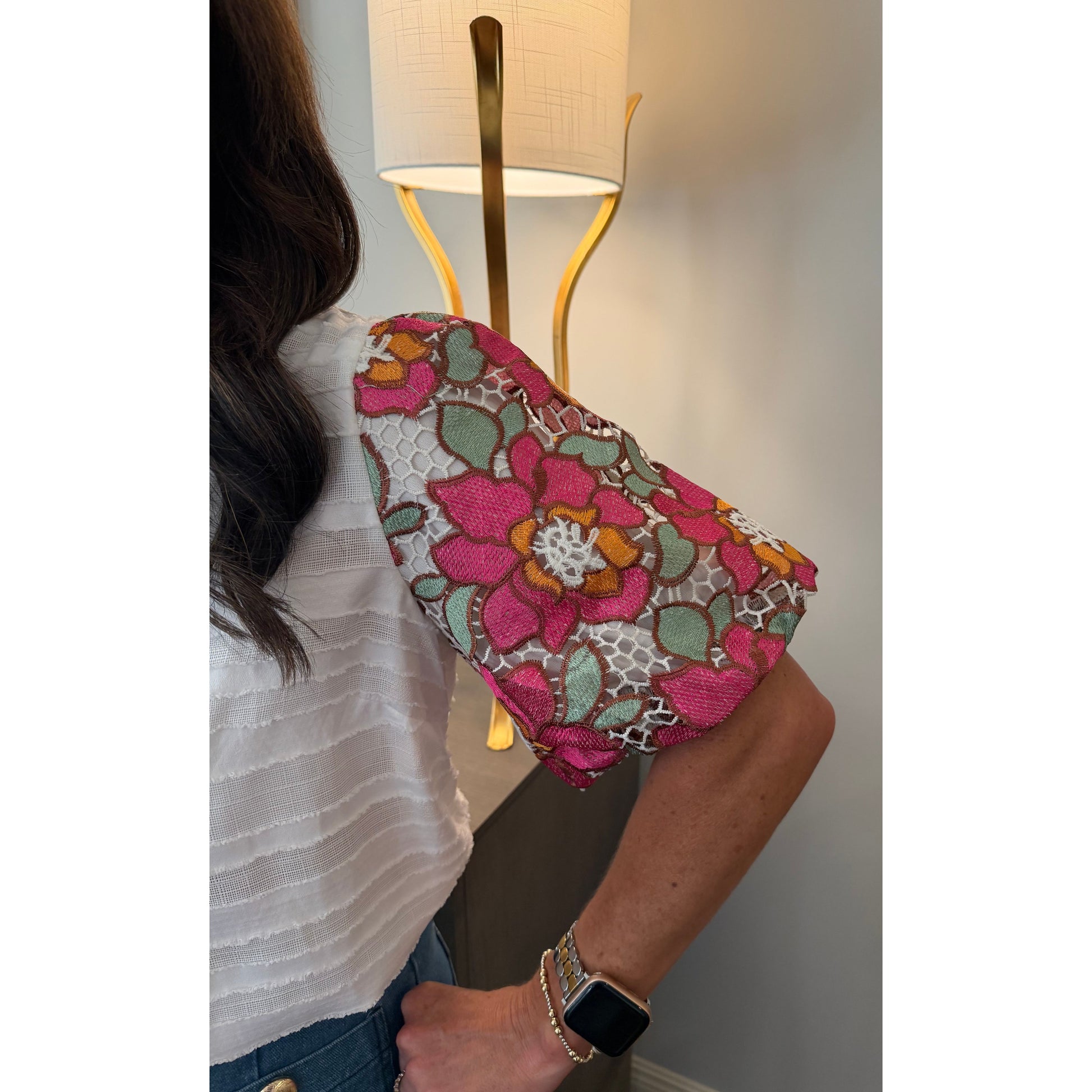 Person wearing a colorful floral headscarf with a lamp in the background