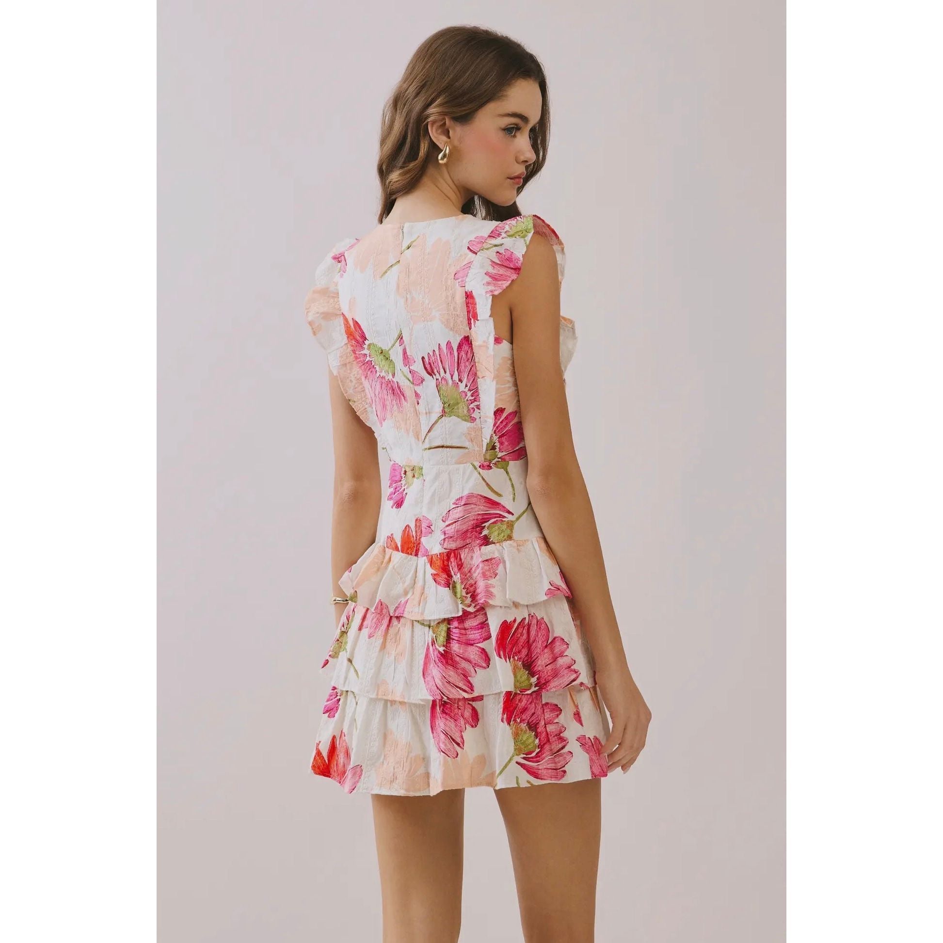 Woman wearing a floral dress against a plain background