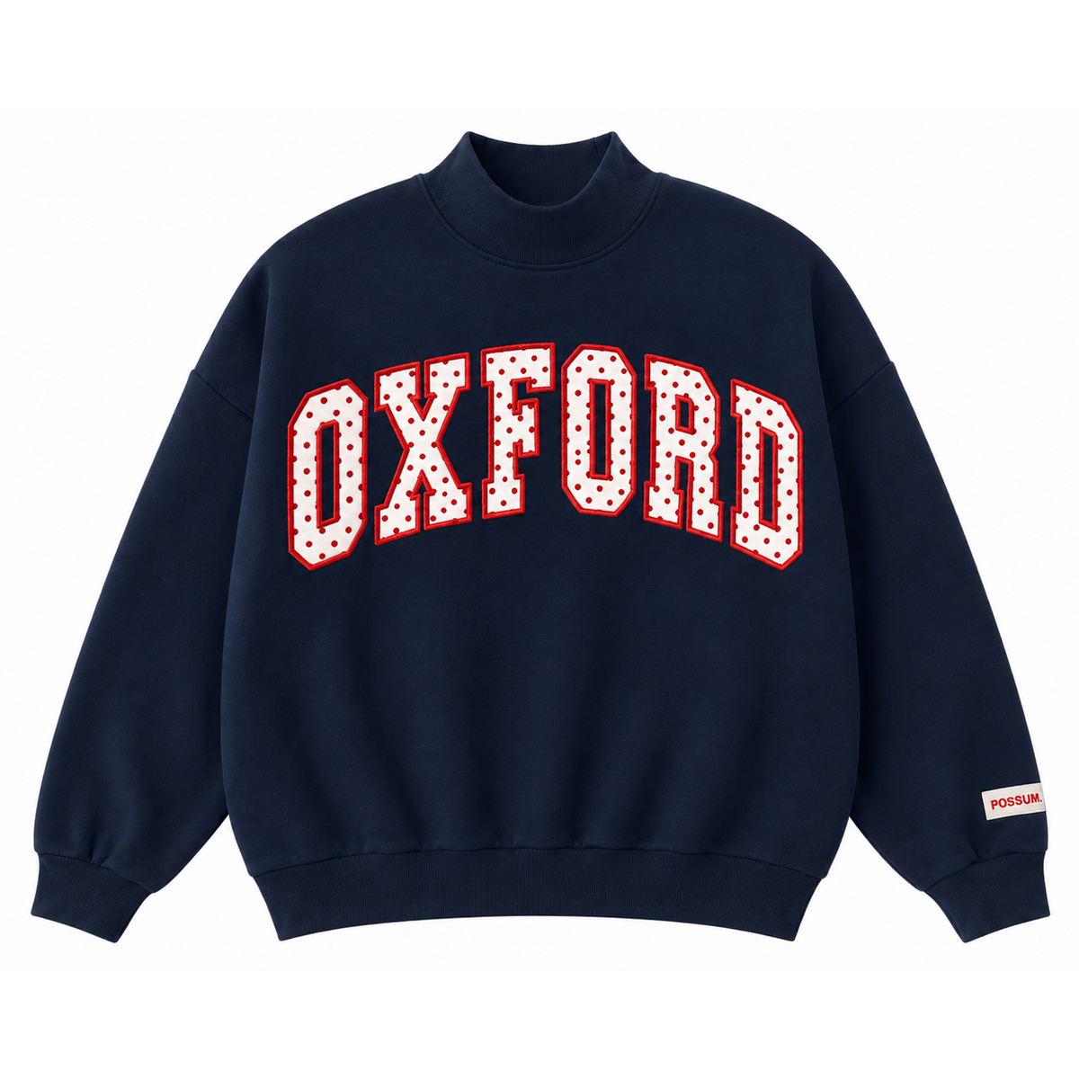 A navy blue crewneck sweatshirt featuring the word 'OXFORD' in arched varsity-style block letters across the chest. The letters are white with red outlines and small white polka dots.