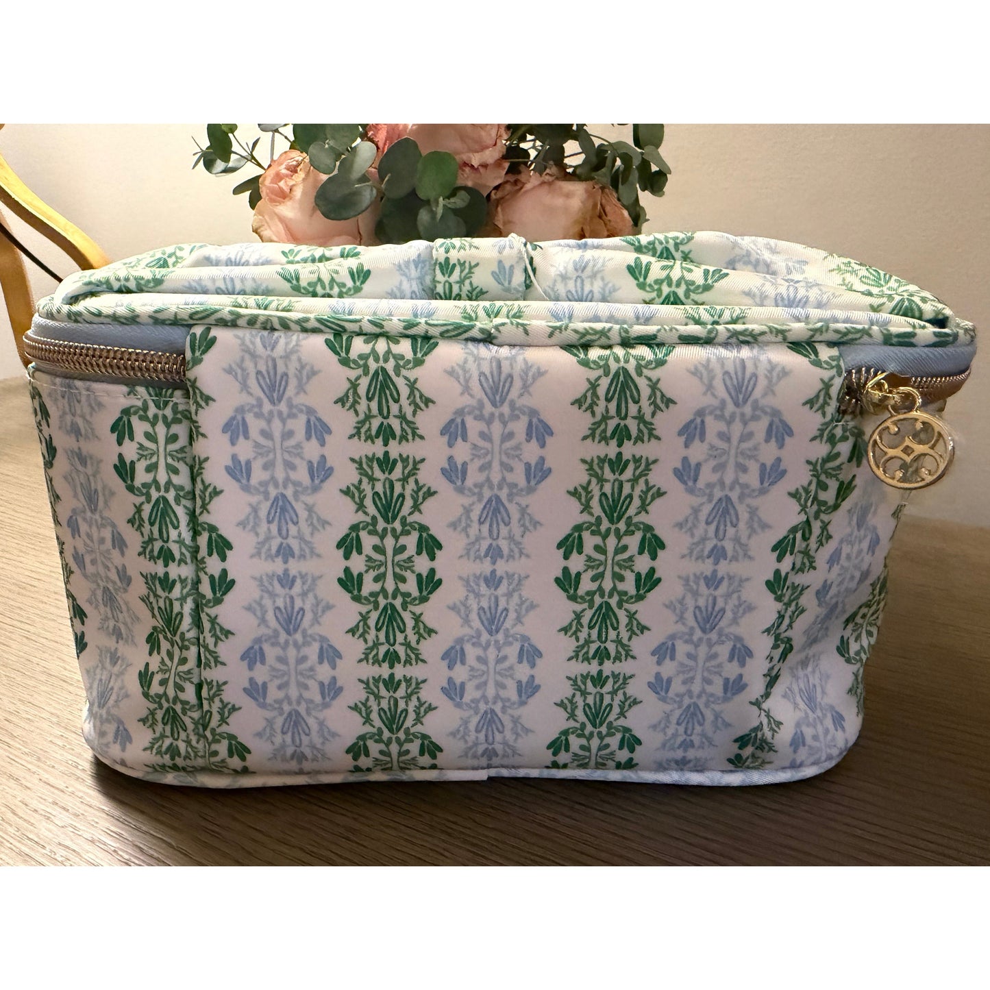 Patterned fabric pouch with floral design on a wooden surface