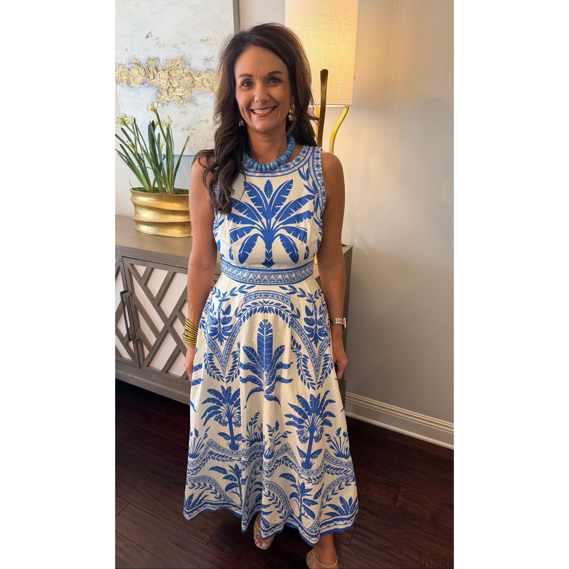 Woman wearing a blue and white patterned dress indoors.