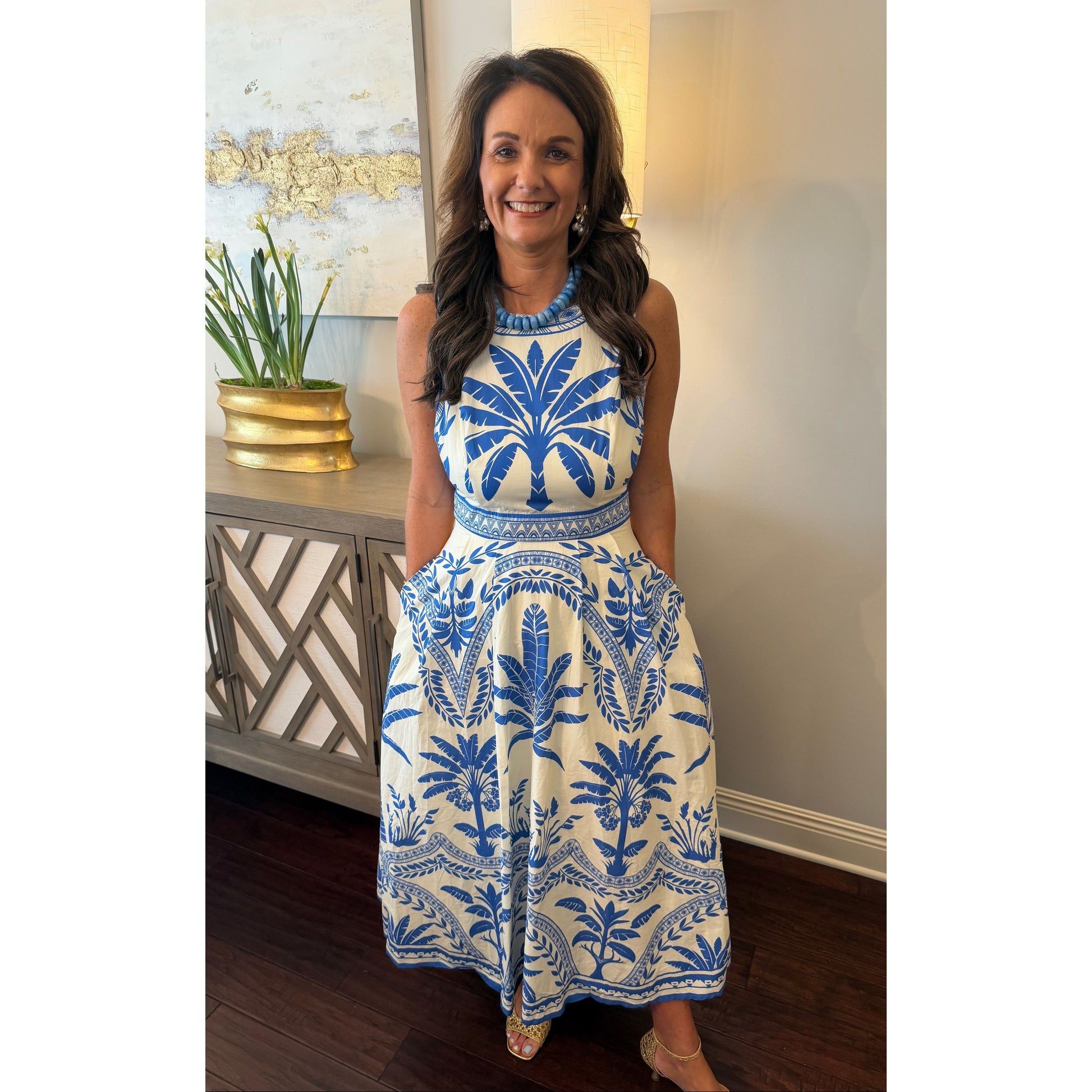 Woman wearing a blue and white patterned dress indoors.